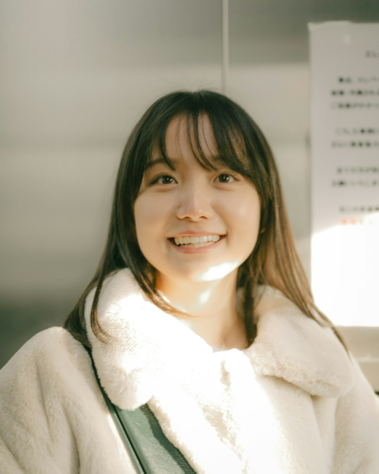 Portrait d'une femme souriante dans un ascenseur avec un éclairage lumineux et des couleurs douces