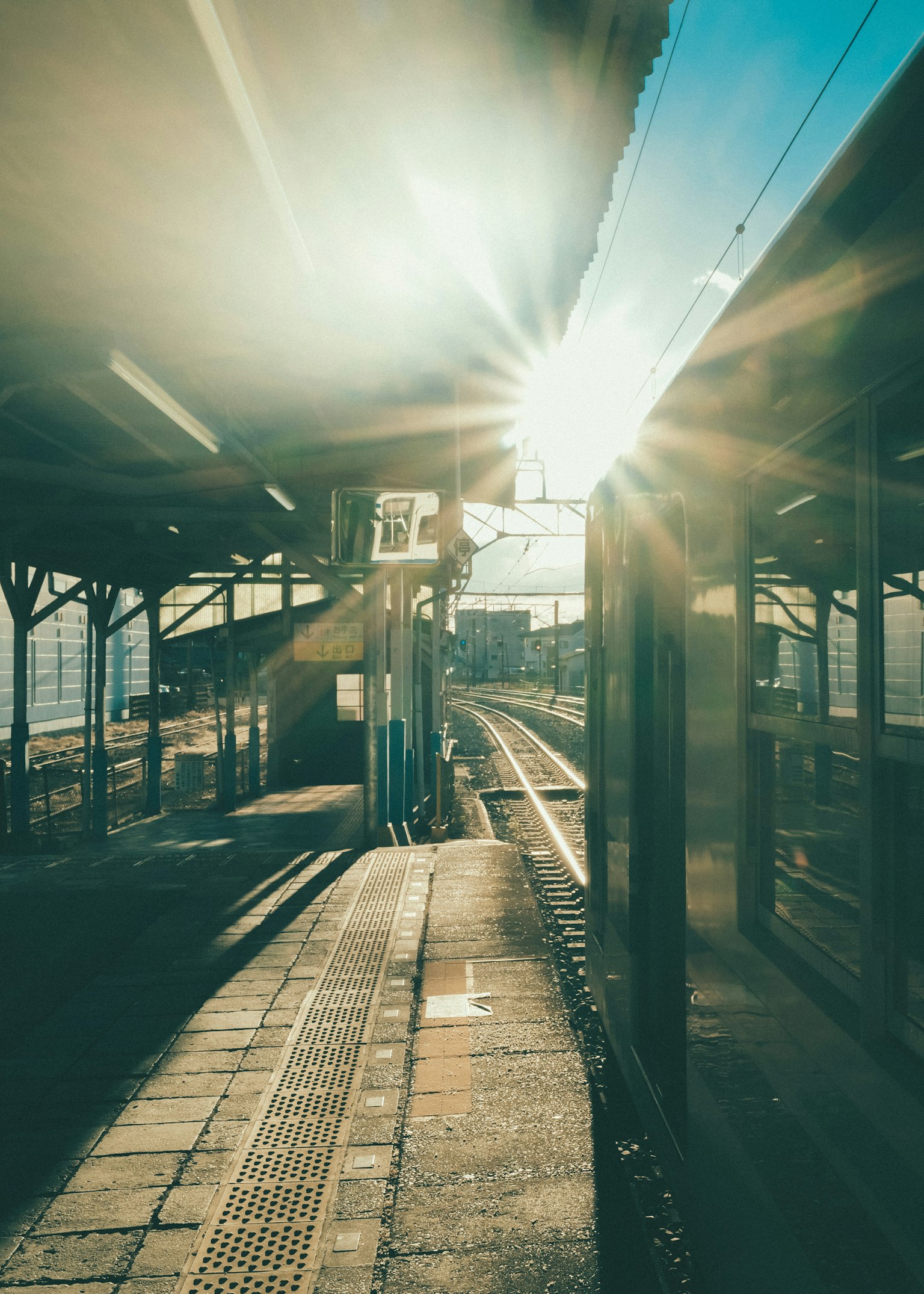 Treno sulla piattaforma con la luce del sole che brilla sullo sfondo