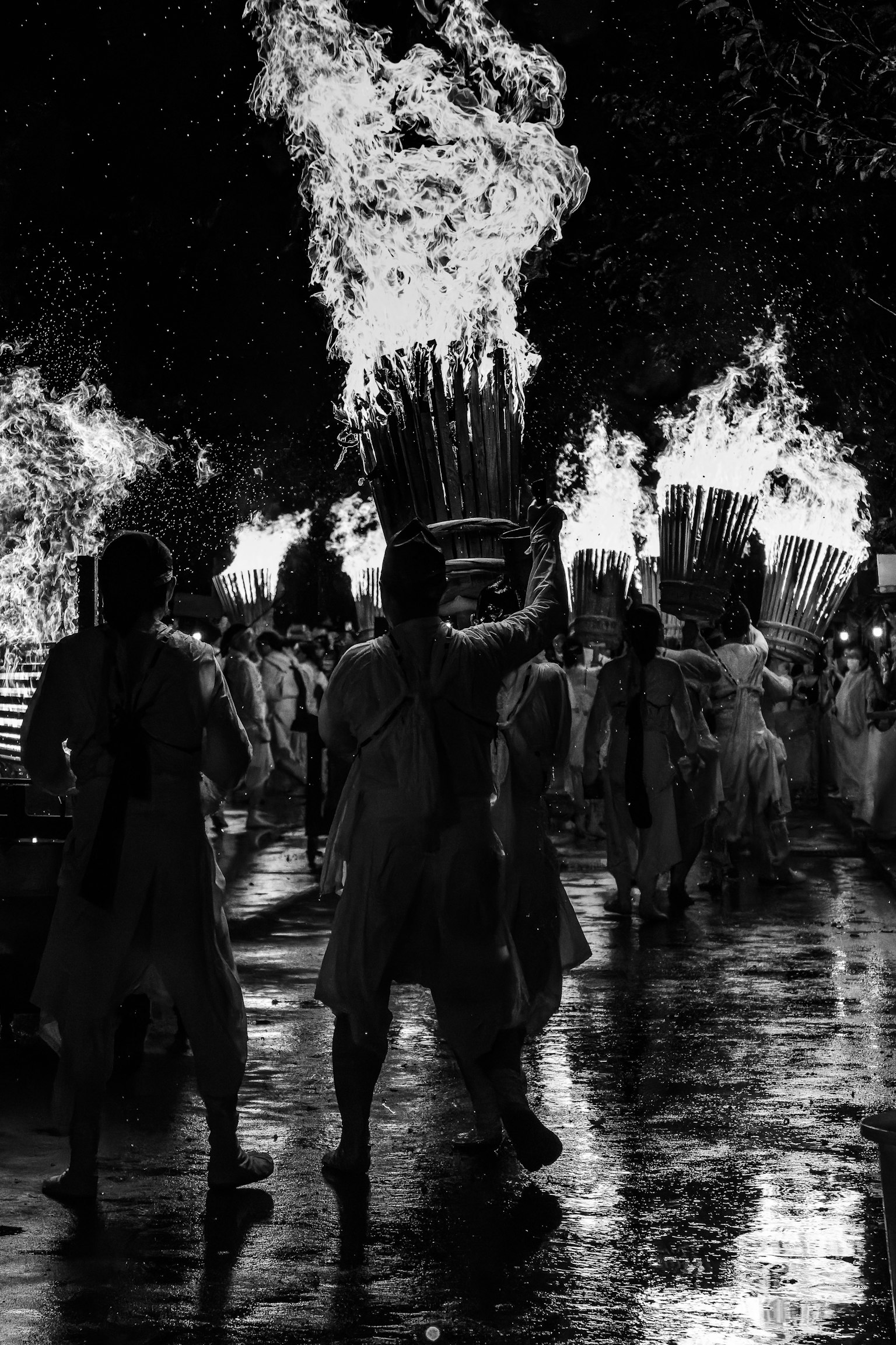 Siluet orang menari di festival api dengan nyala