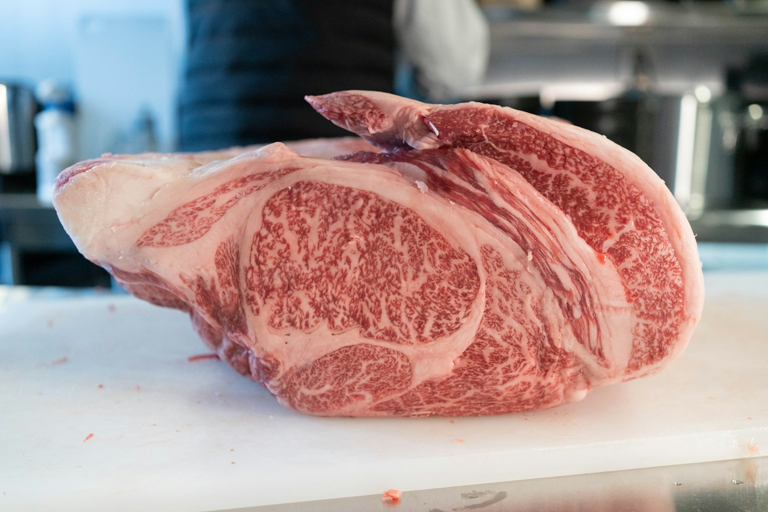 Un hermoso corte de carne de Wagyu veteado sobre una tabla de cortar blanca