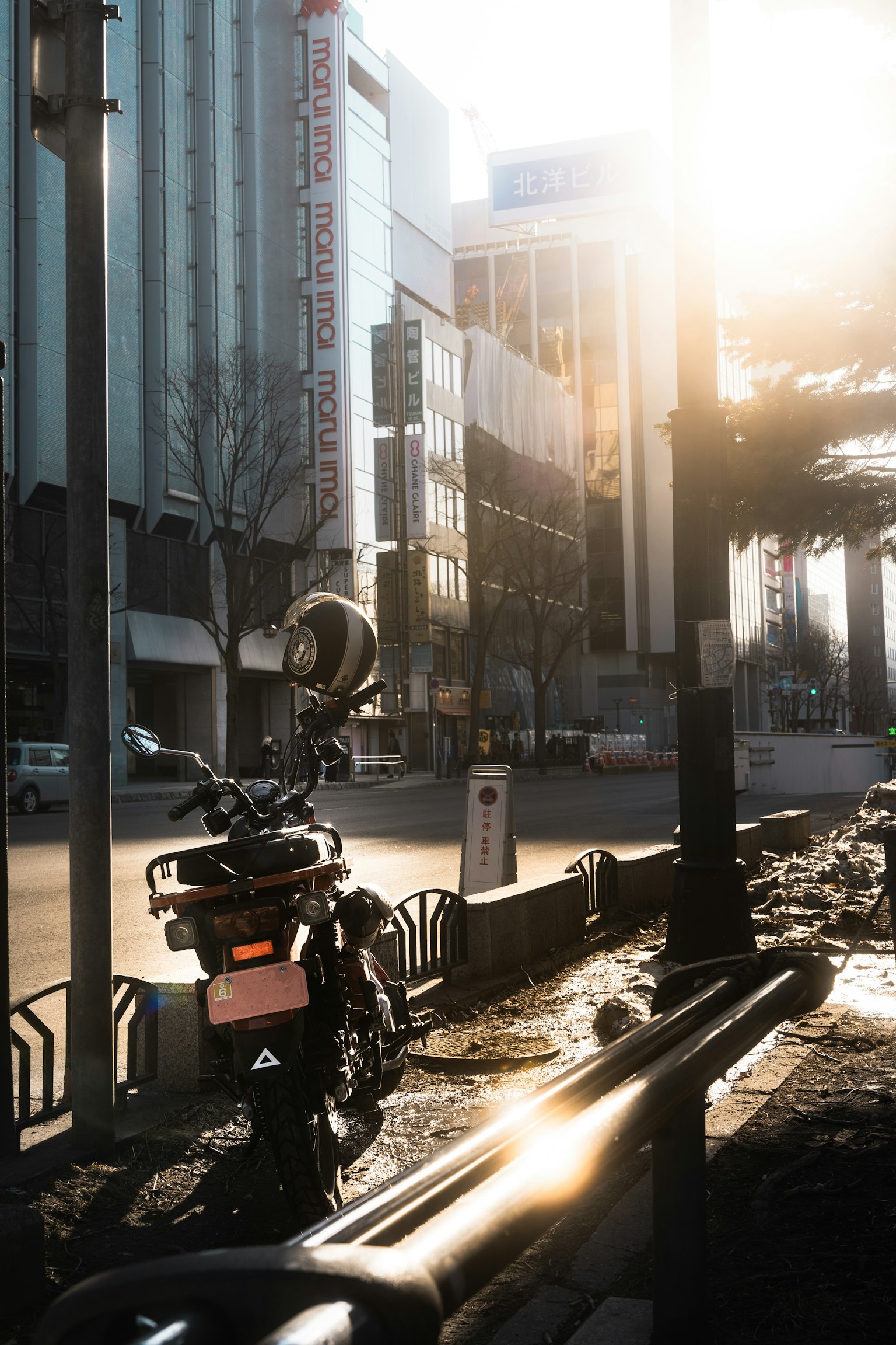 Urban street scene with a parked motorcycle and sunlight shining