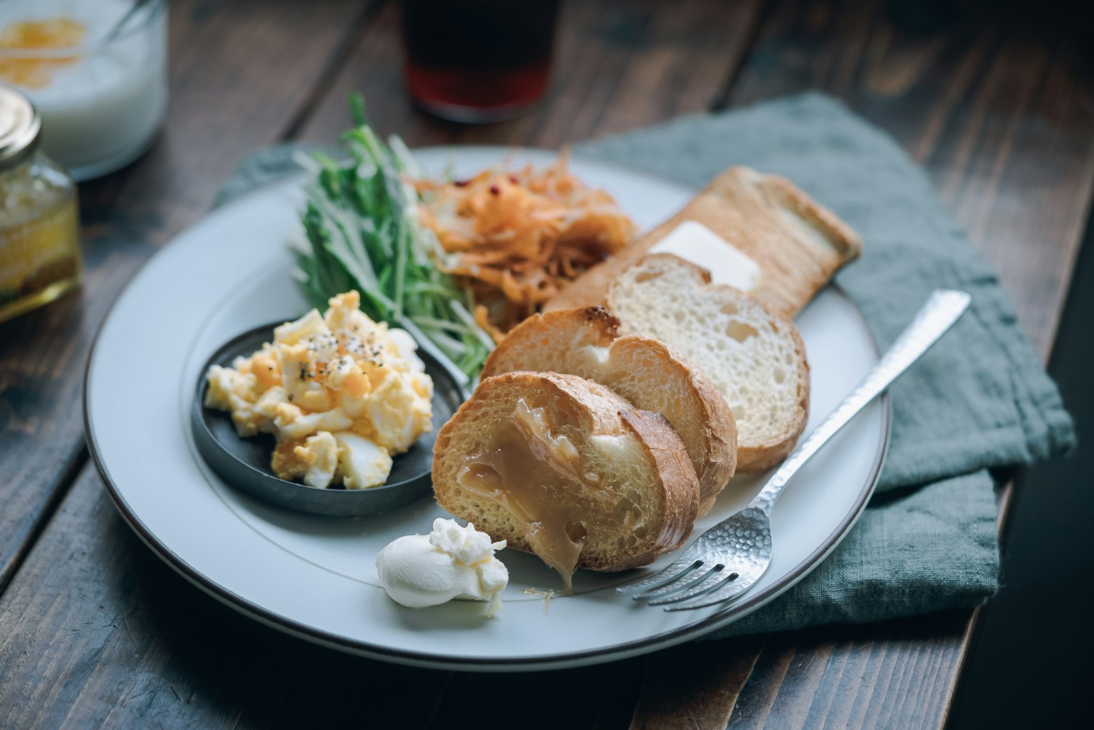 Piatto per colazione con uova strapazzate, pane, verdure e panna acida