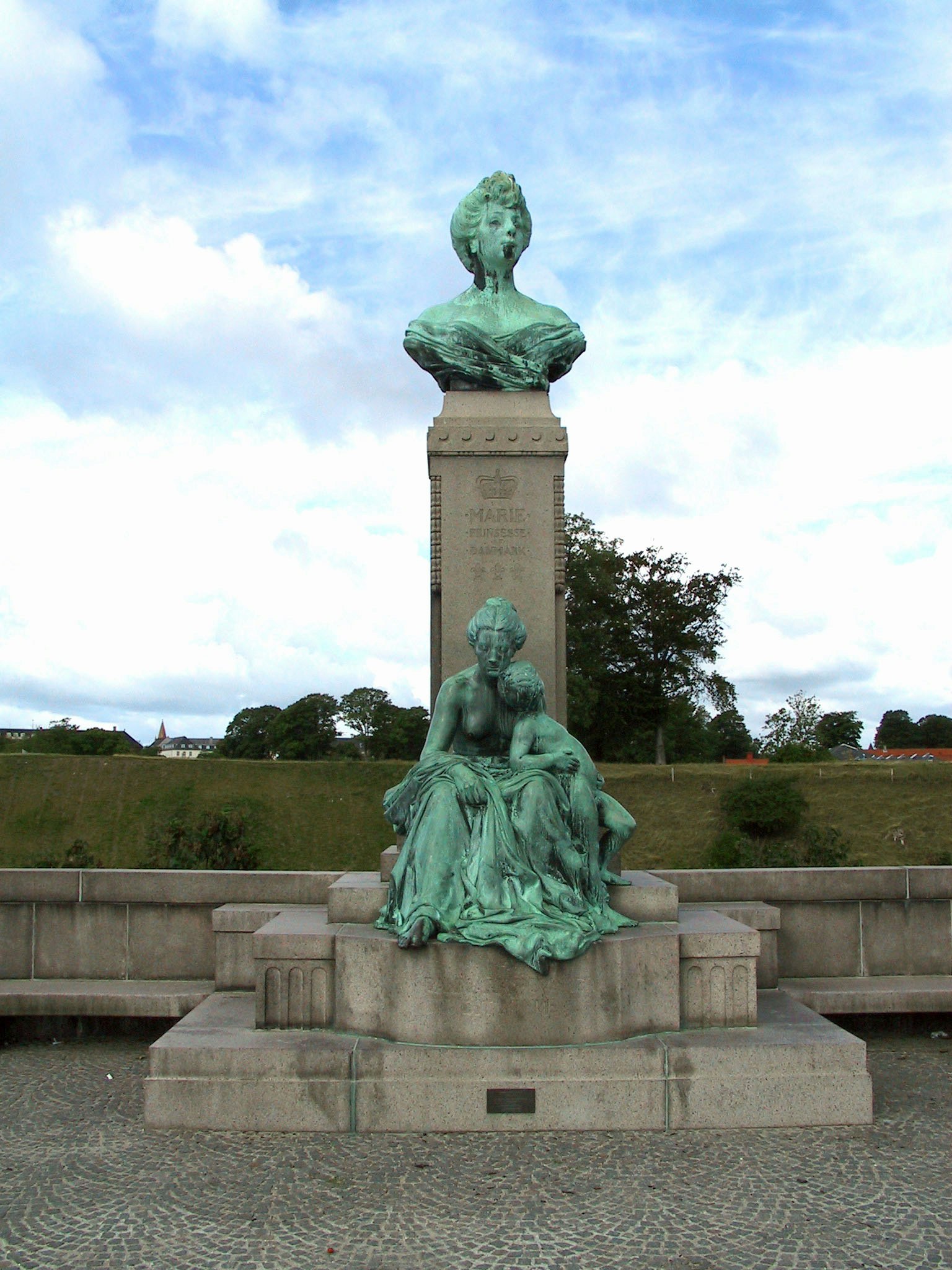 bronze statue on a grassy plaza