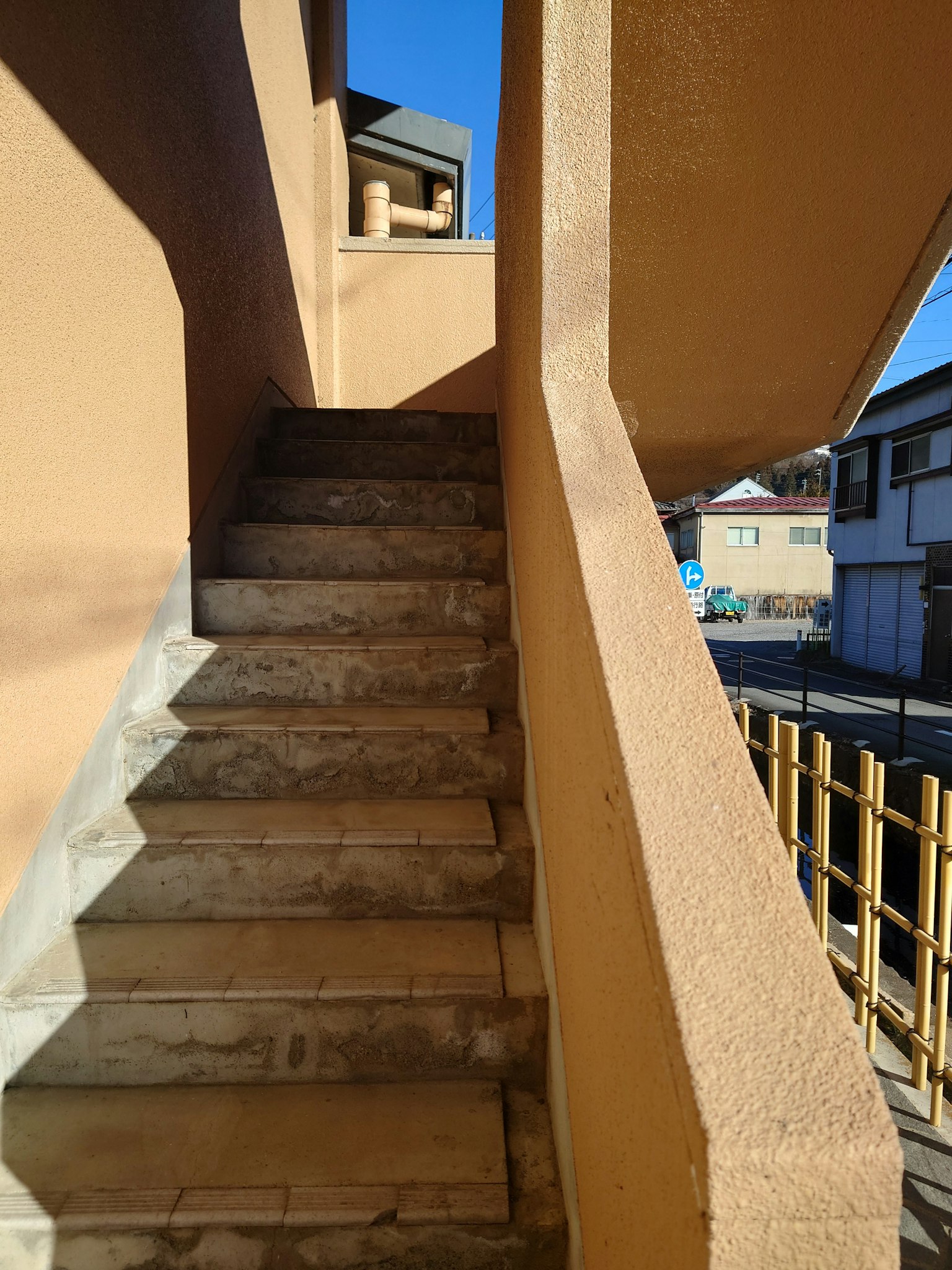 Treppe mit hellen Wänden und klarem Himmel