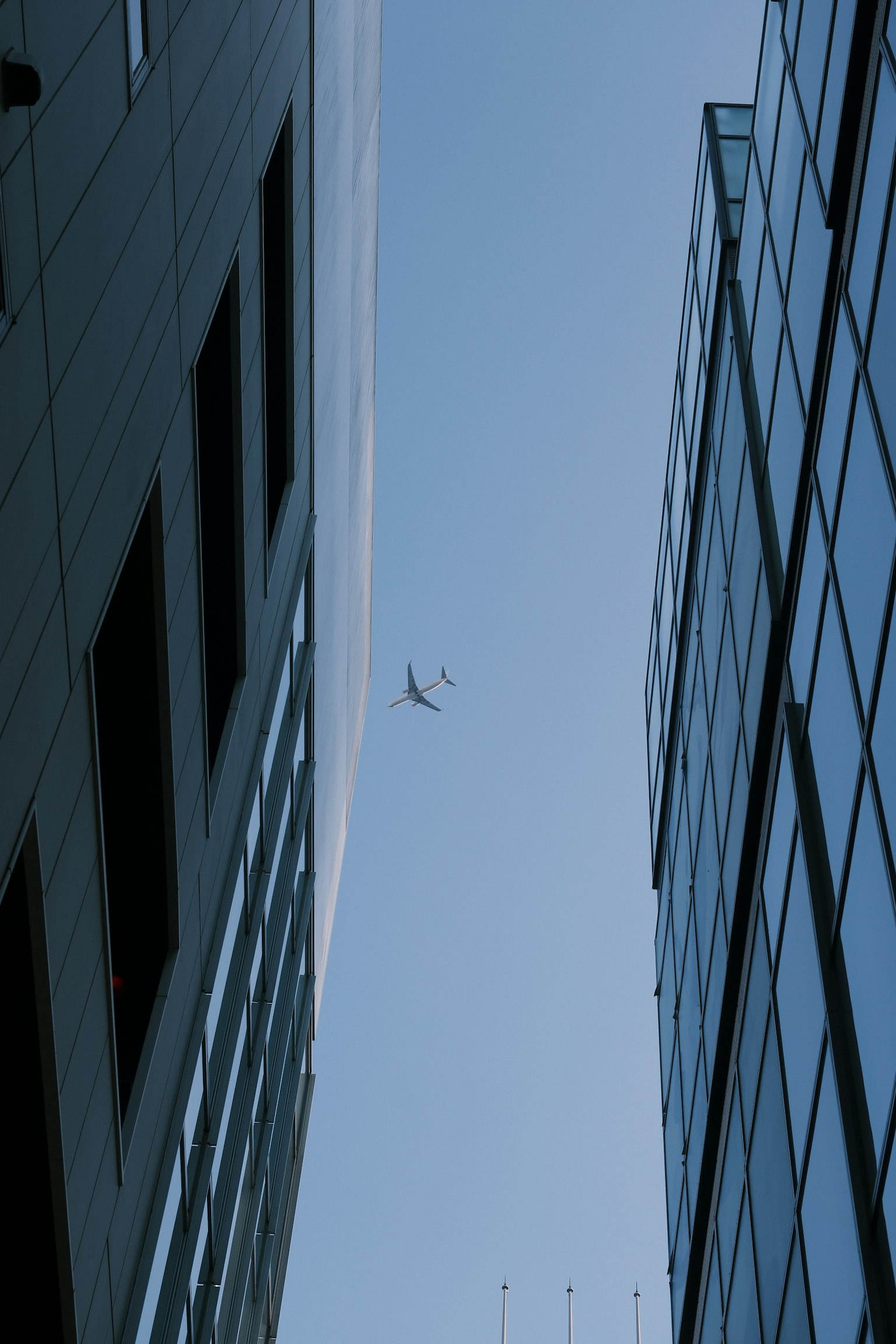 Drone che vola tra grattacieli contro un cielo blu