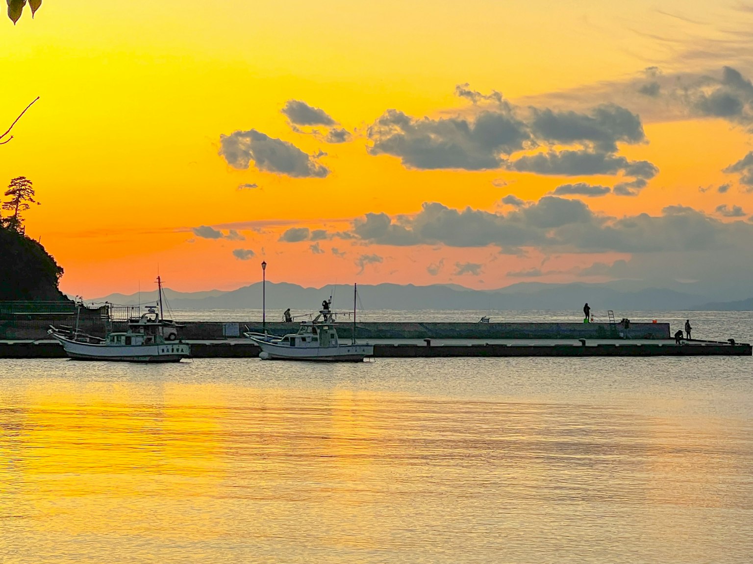 Barche da pesca ormeggiate al tramonto su una costa con acque calme