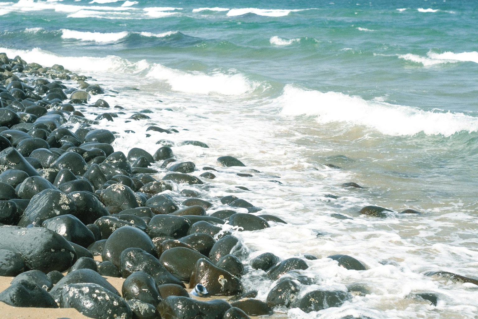 Vista costera con piedras negras y olas