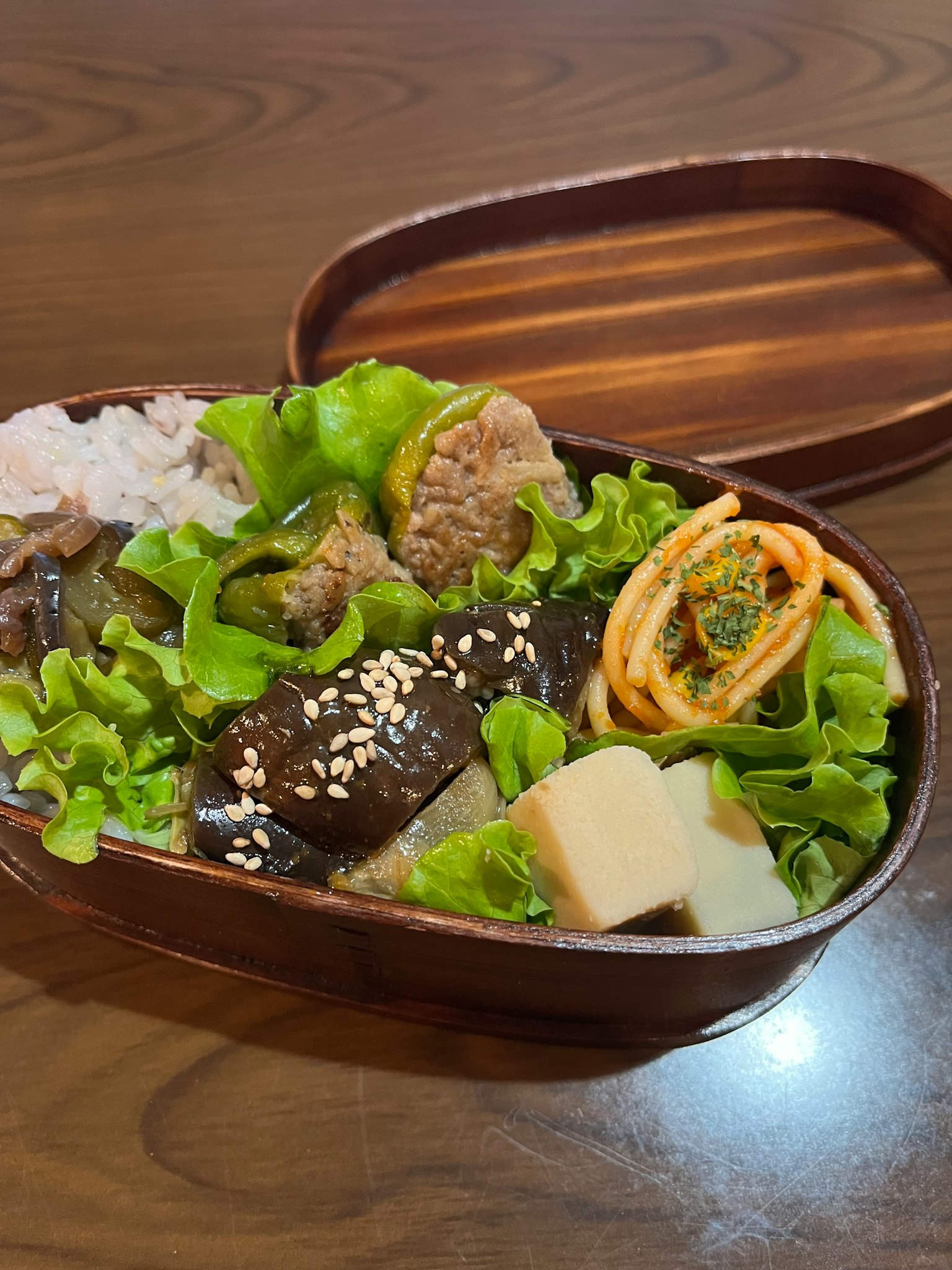 Caja bento de madera llena de lechuga fresca y una variedad de platos