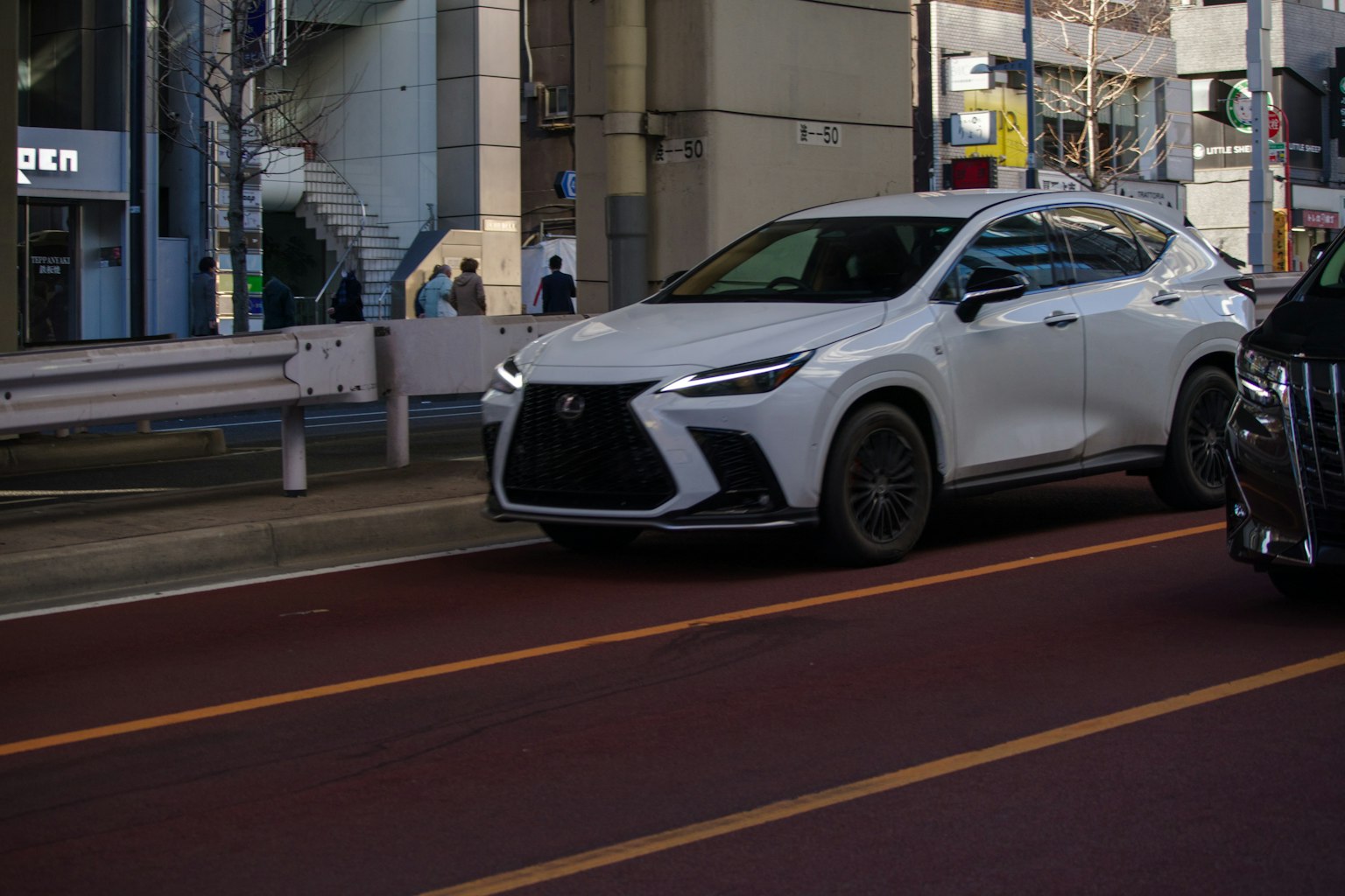 Un SUV bianco che guida su una strada urbana con edifici sullo sfondo