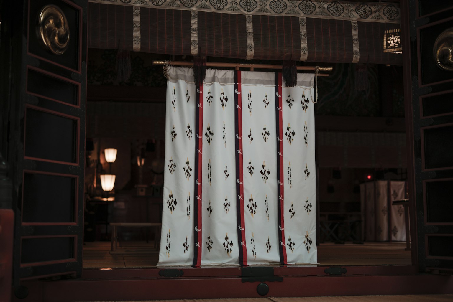 Traditional Japanese entrance with white noren curtains featuring red patterns
