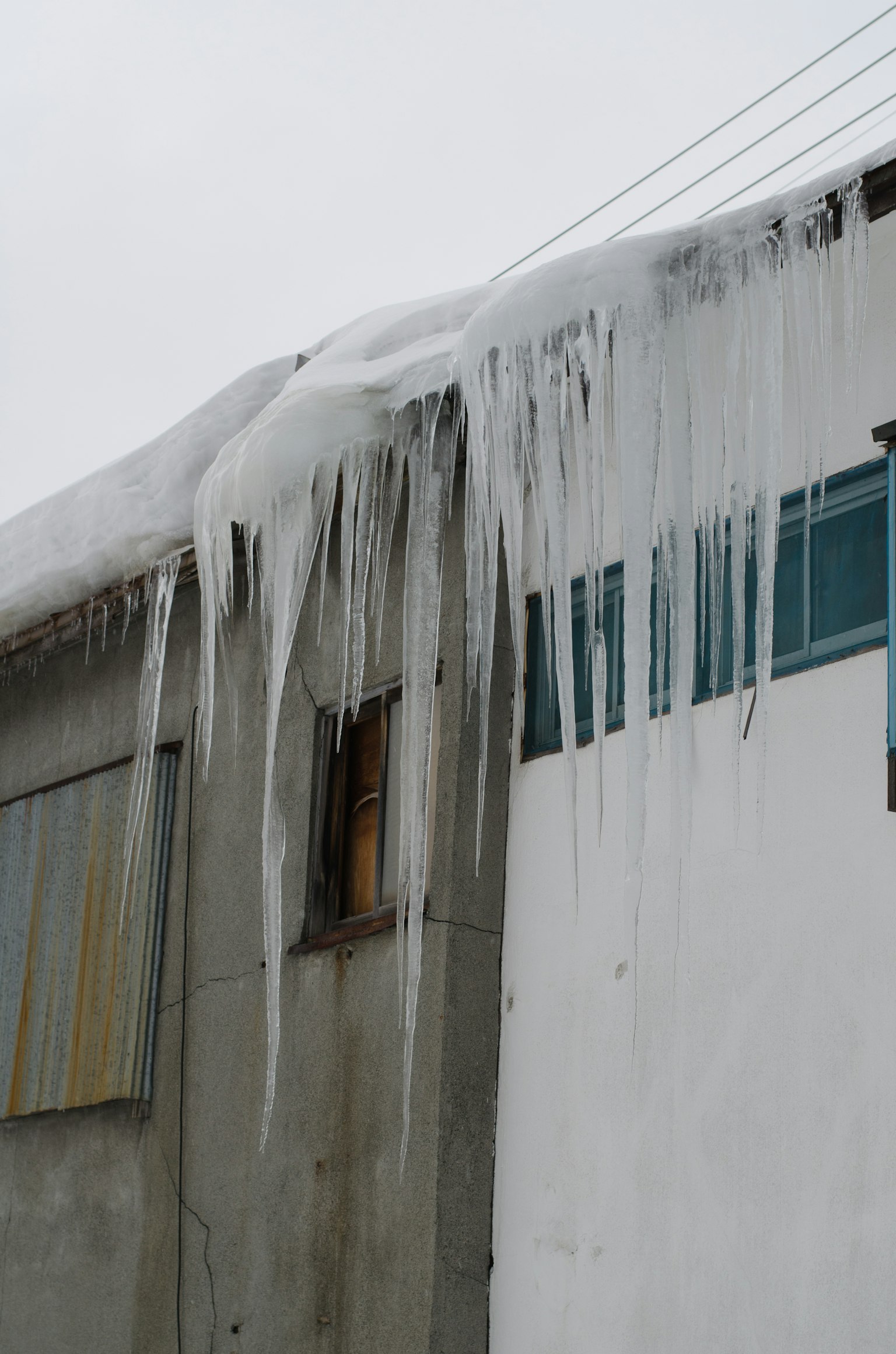 从屋顶上有雪的建筑上挂着冰柱