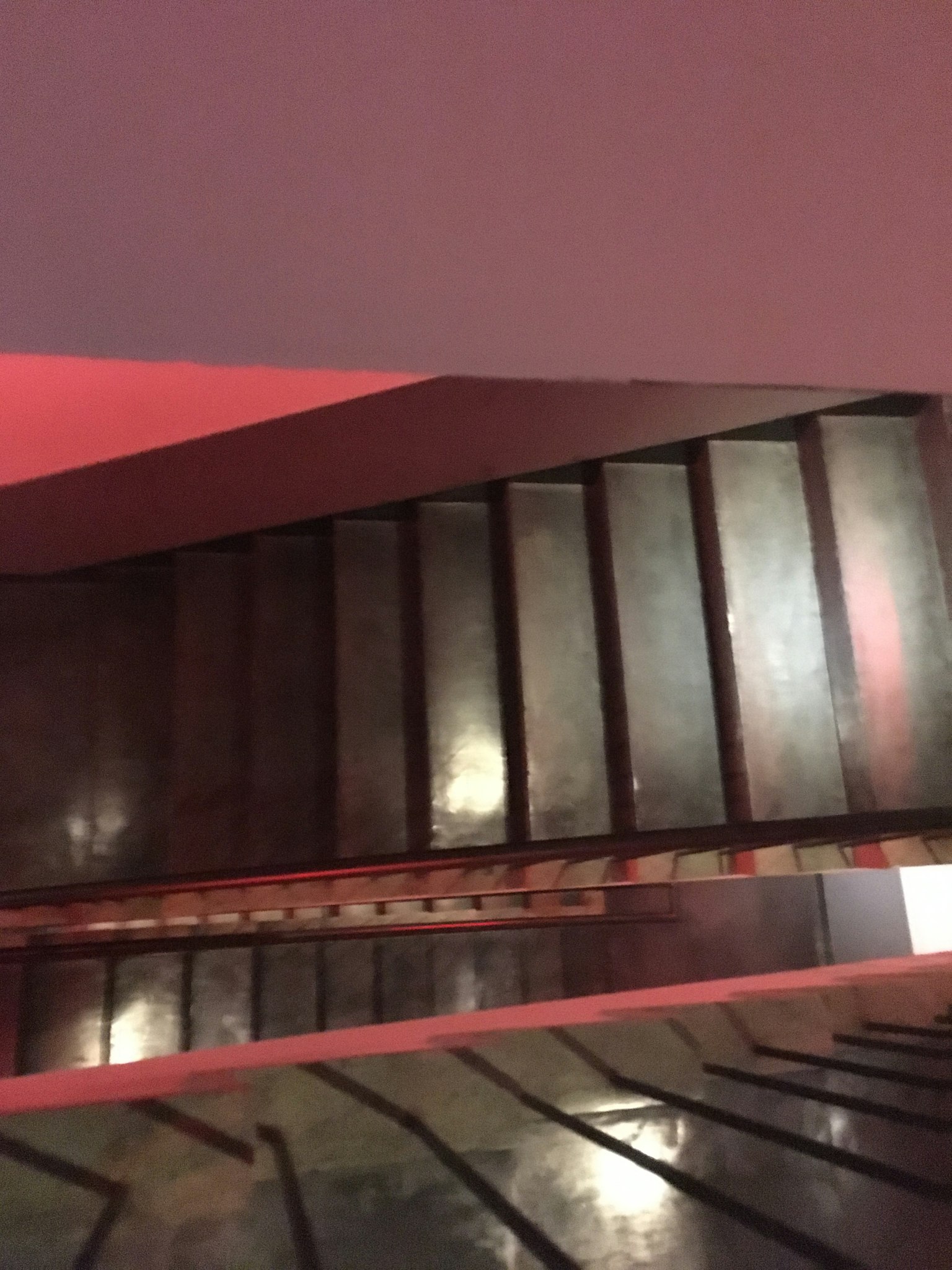 Foto de escaleras vistas desde arriba Escaleras de madera oscura iluminadas por luces rojas