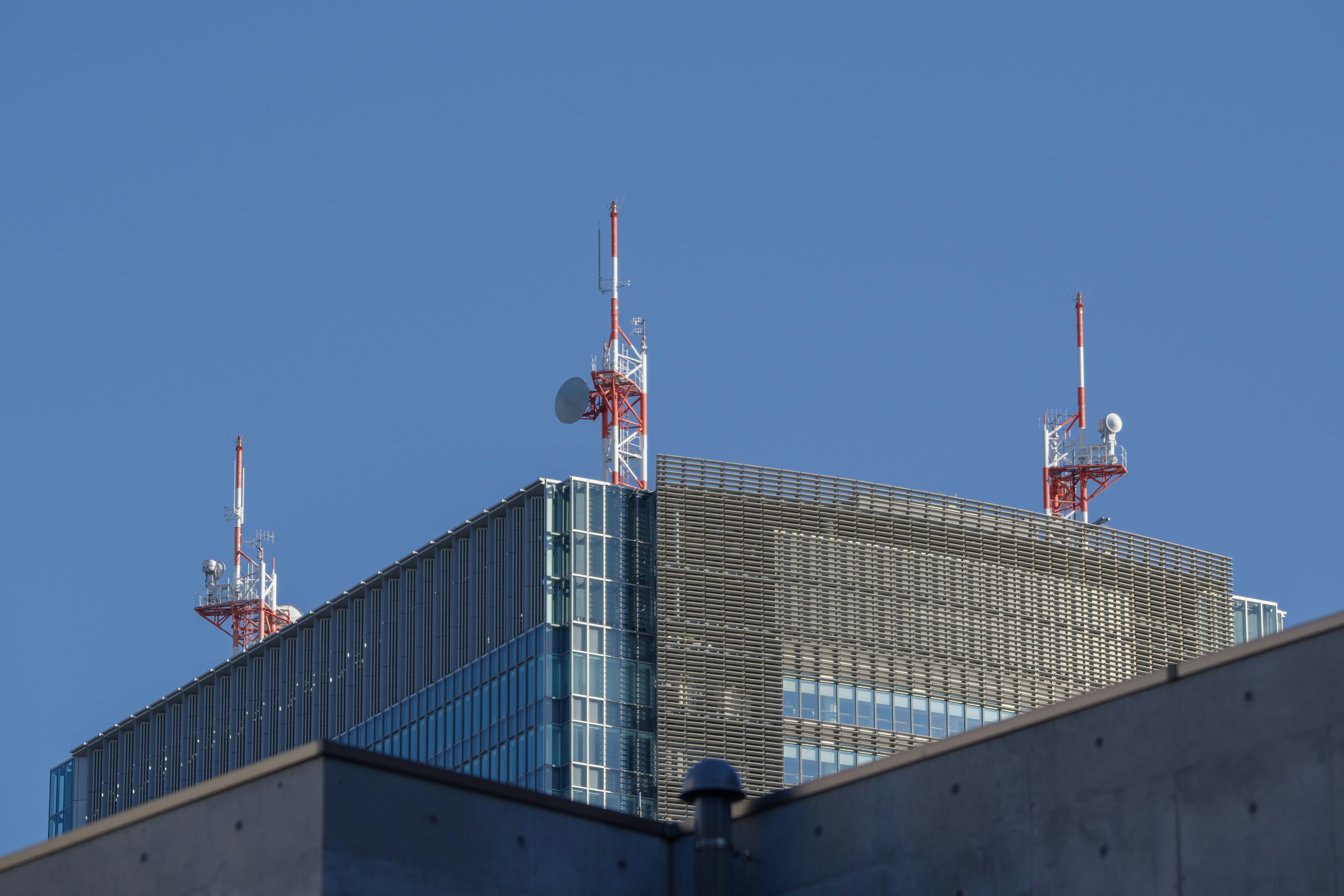 晴朗蓝天下建筑屋顶的通信天线