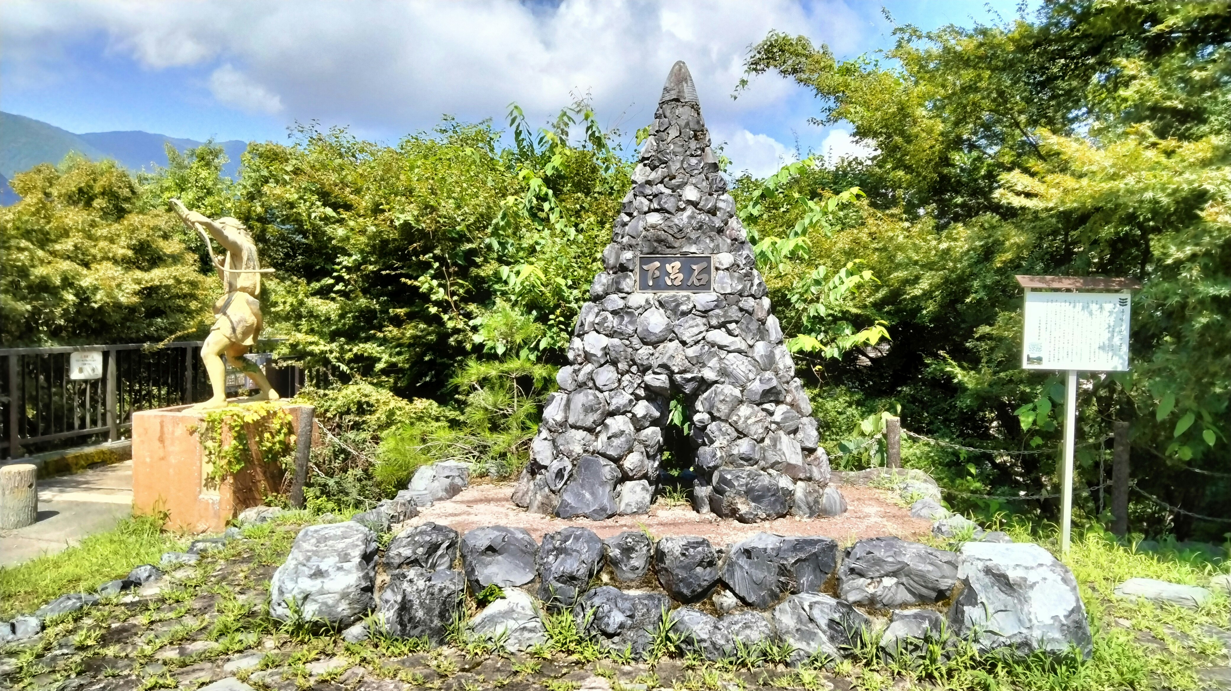 stone-stacked monument in a garden with lush greenery