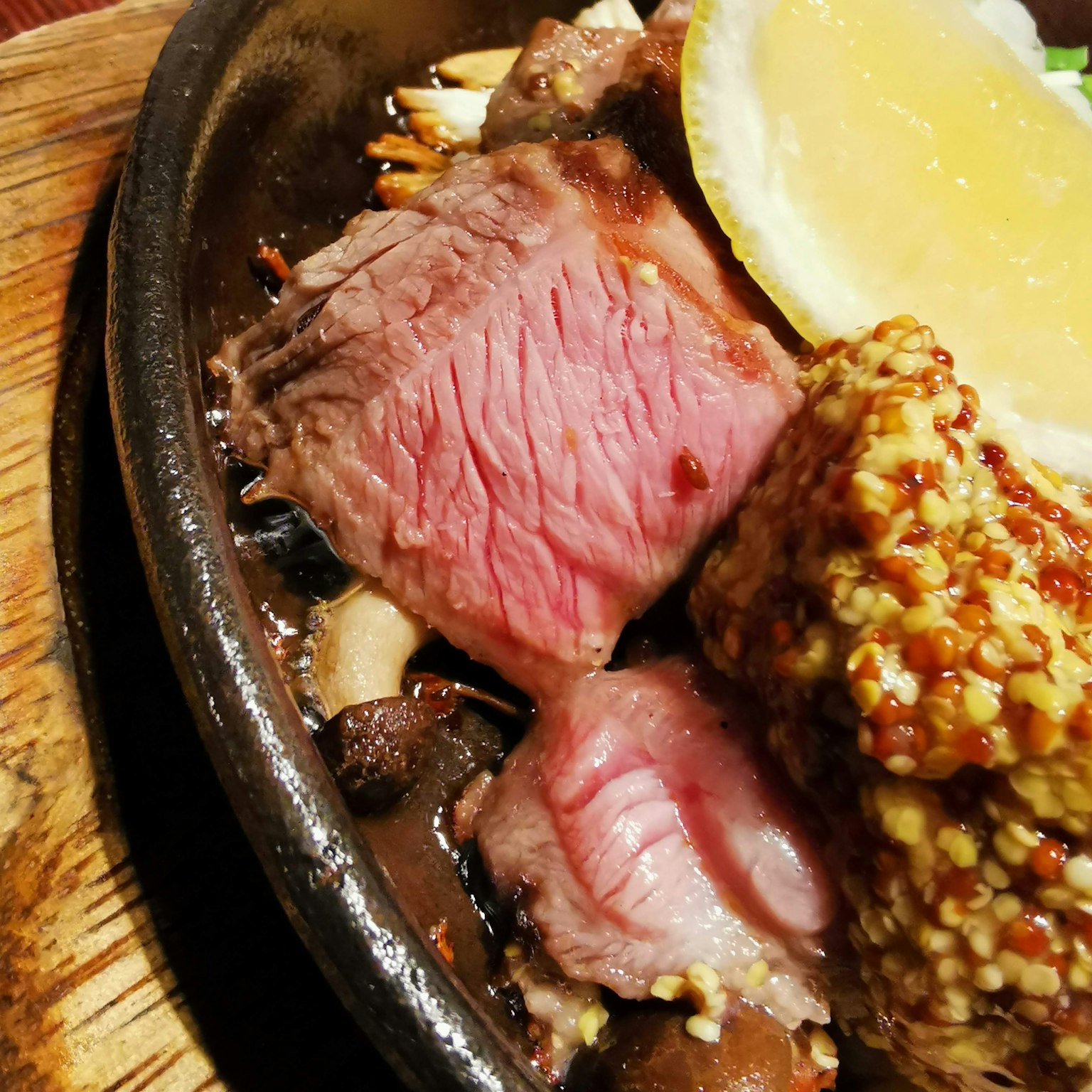Bistecca succulenta servita su un piatto sfrigolante con una fetta di limone