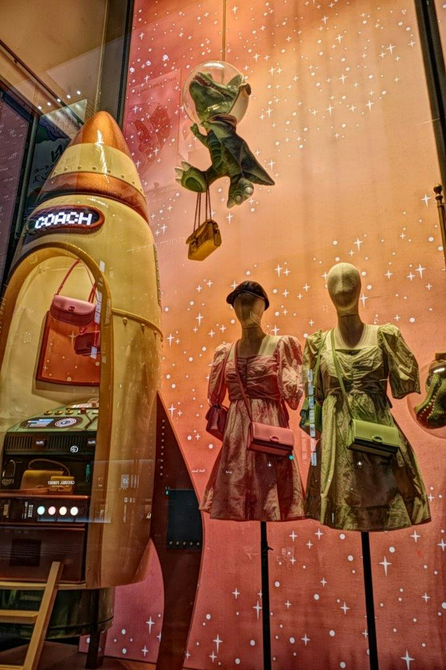 Vestidos de moda exhibidos en una ventana con una exhibición en forma de cohete