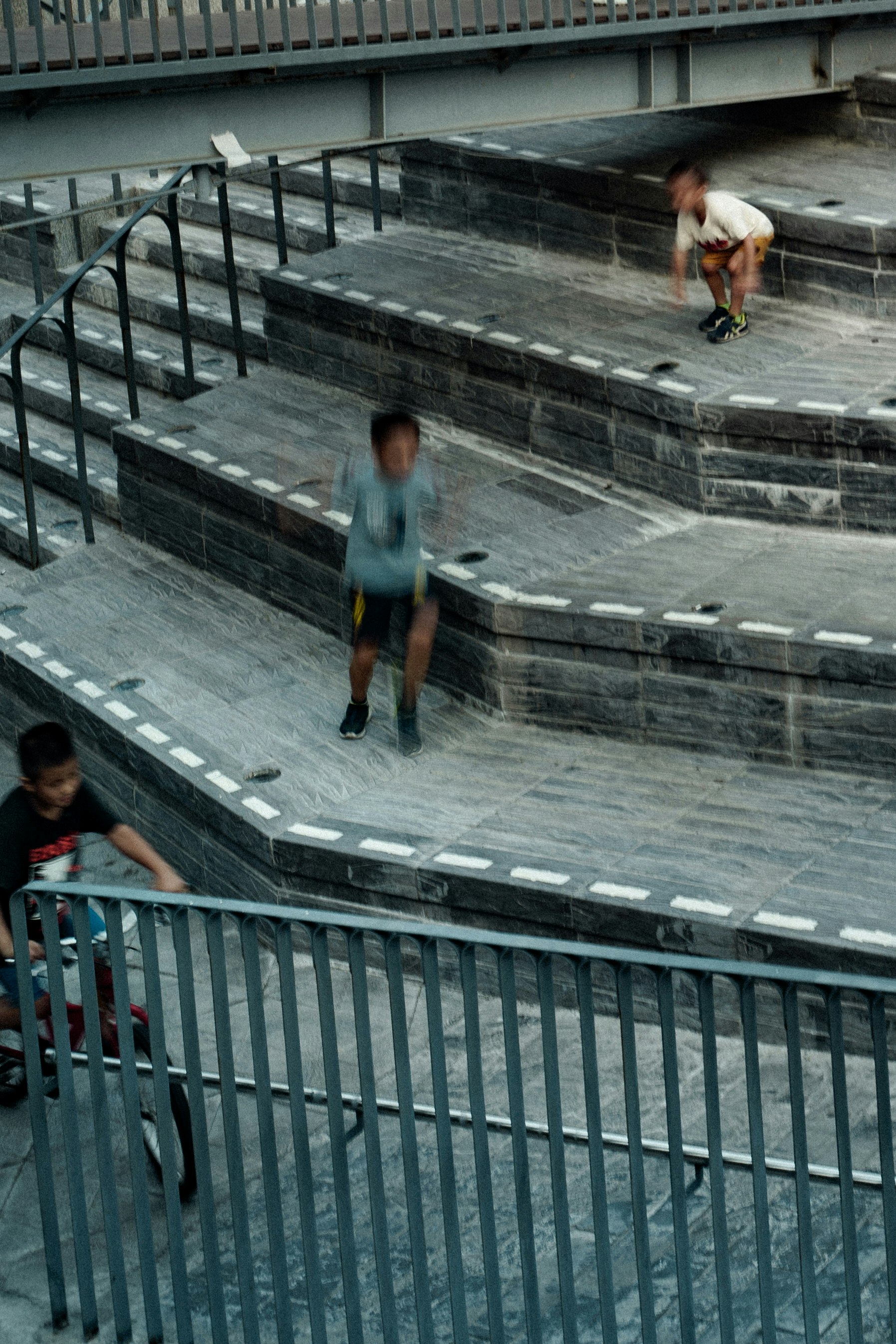 階段状の屋外通路を歩く人々のある街の風景