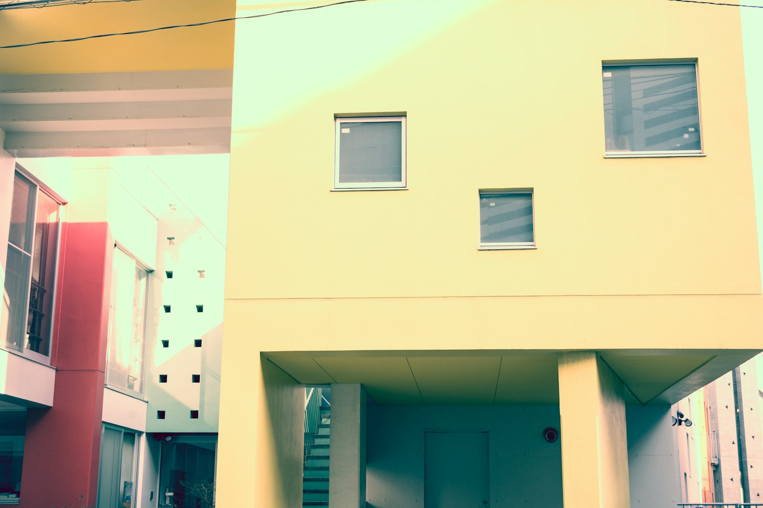 Architecture moderne avec un bâtiment jaune vif et des fenêtres uniques