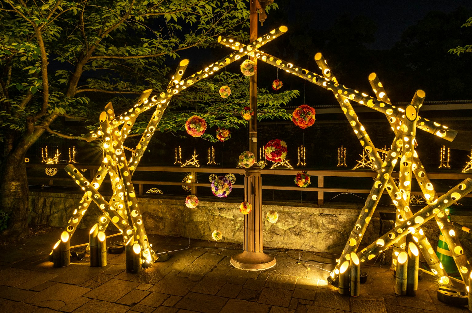 Decoraciones de bambú iluminadas con adornos coloridos en un entorno nocturno