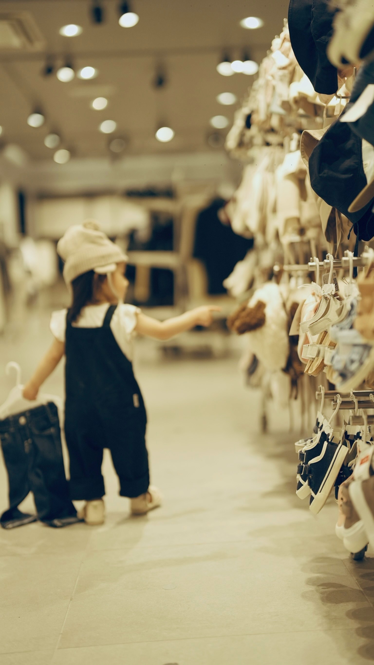 子供が服を選んでいる様子 店内の明るい照明と商品棚が見える