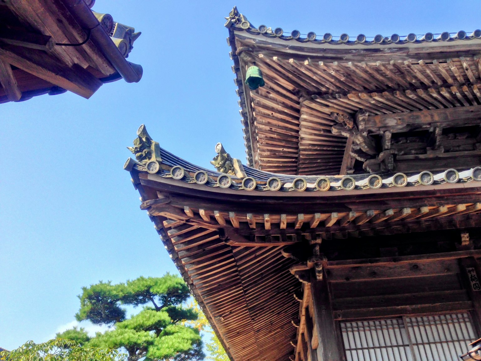 Detaillierte Ansicht eines traditionellen japanischen Architekturdachs vor blauem Himmel