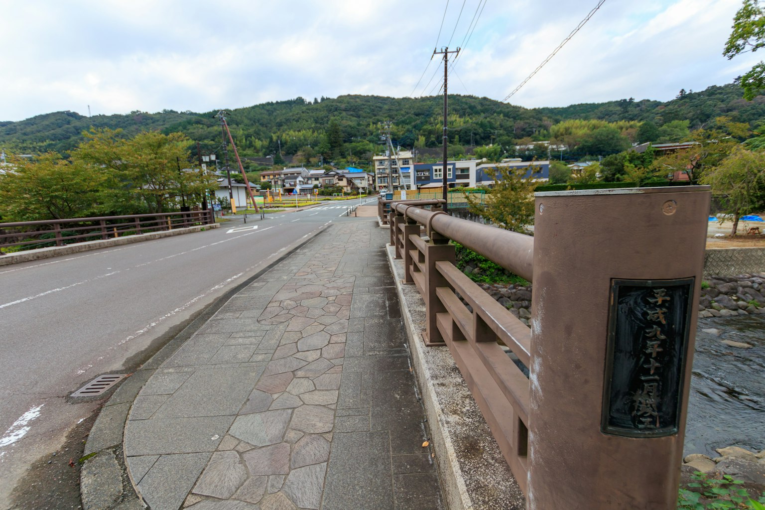 Vista di un ponte e di una strada con colline verdi e edifici sullo sfondo