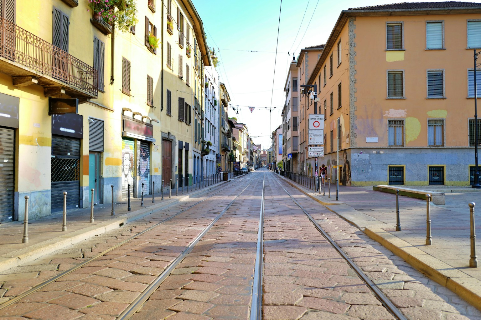 Scène de rue calme à Milan avec des rails de tram et des bâtiments