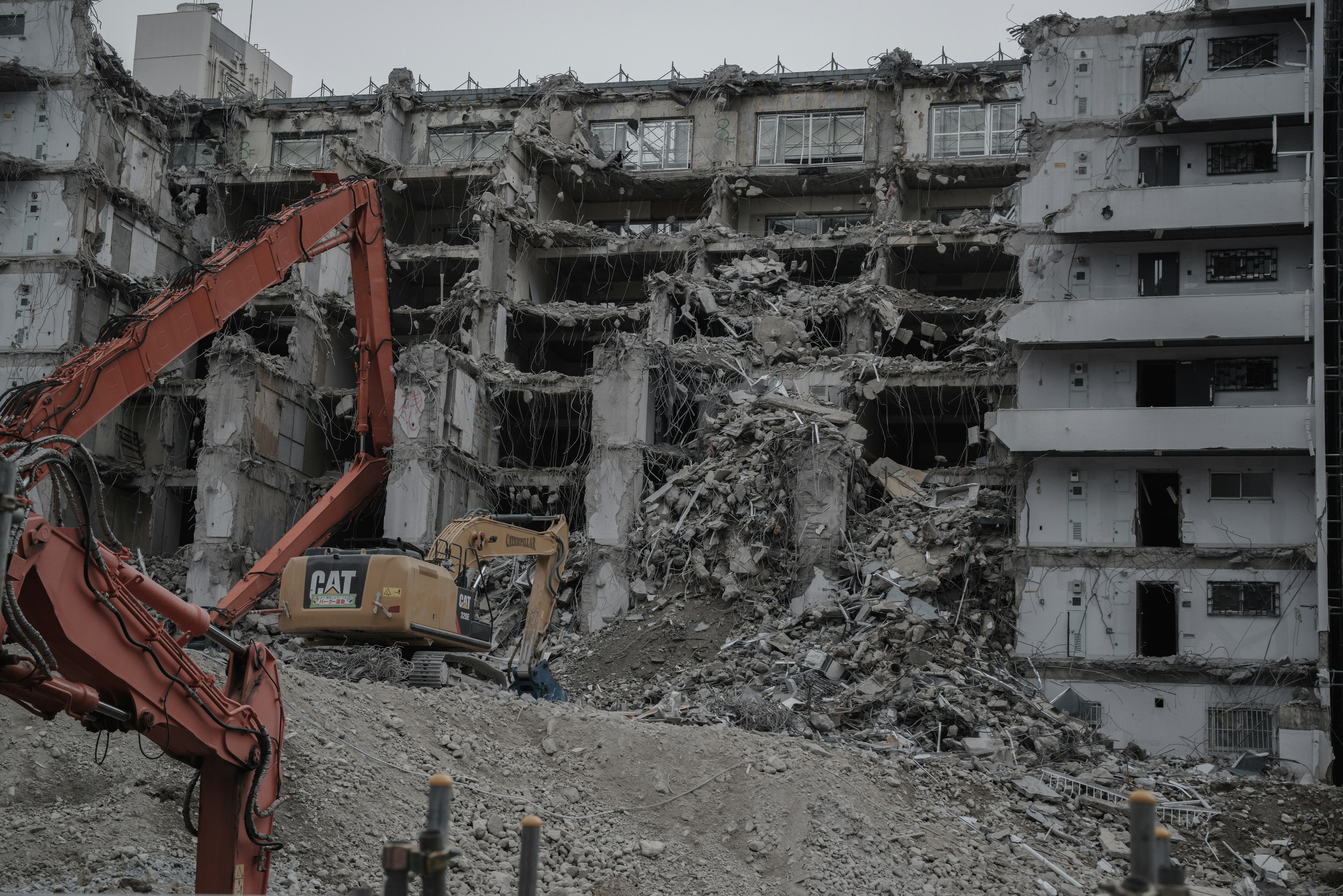 Abrissbaustelle mit eingestürzten Gebäuden und schweren Maschinen