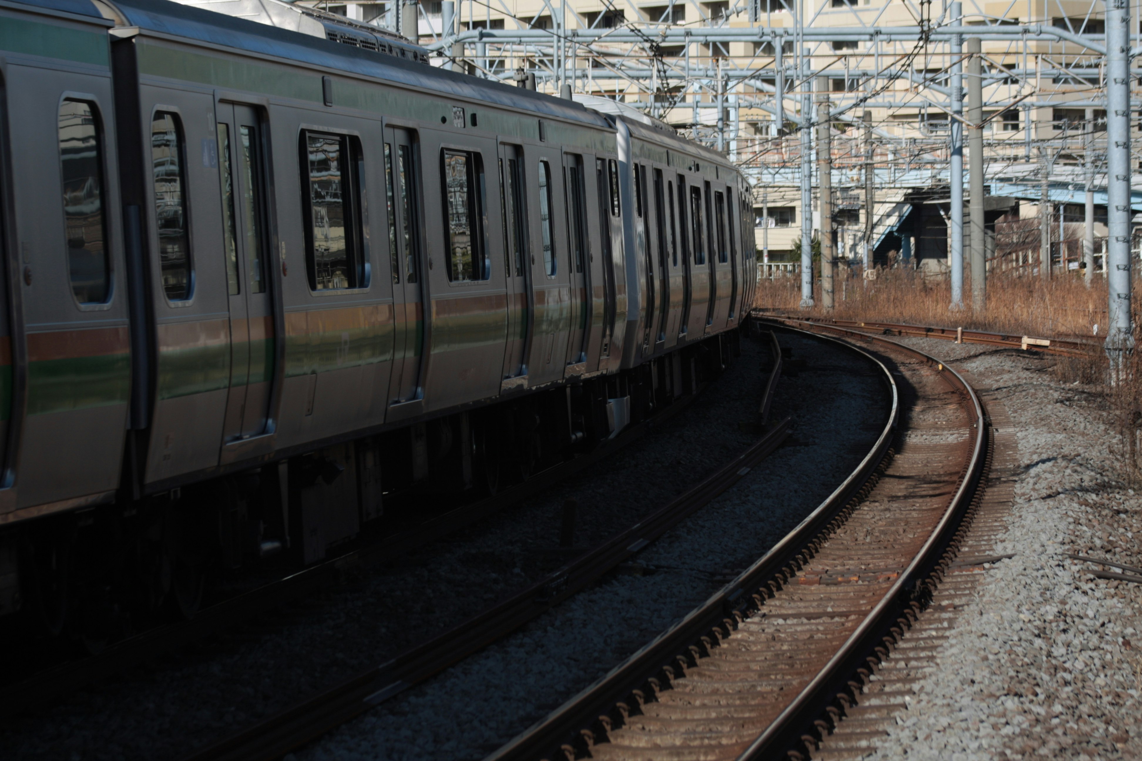 線路を走る電車の側面とカーブするホームの風景