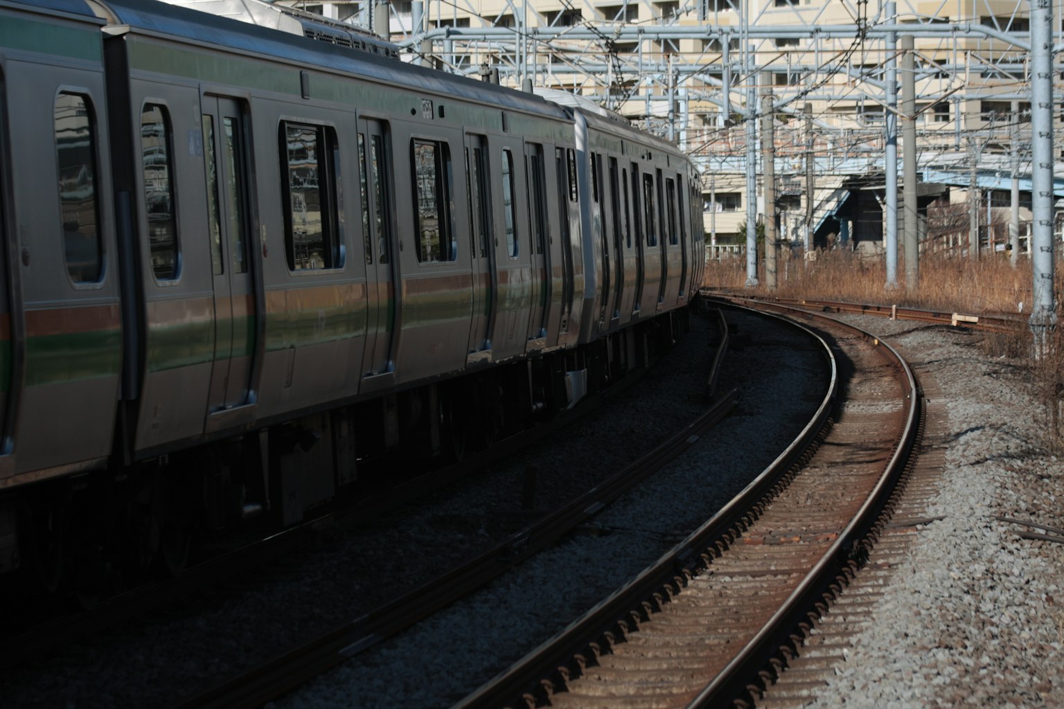 Treno argento che si muove lungo un binario curvo