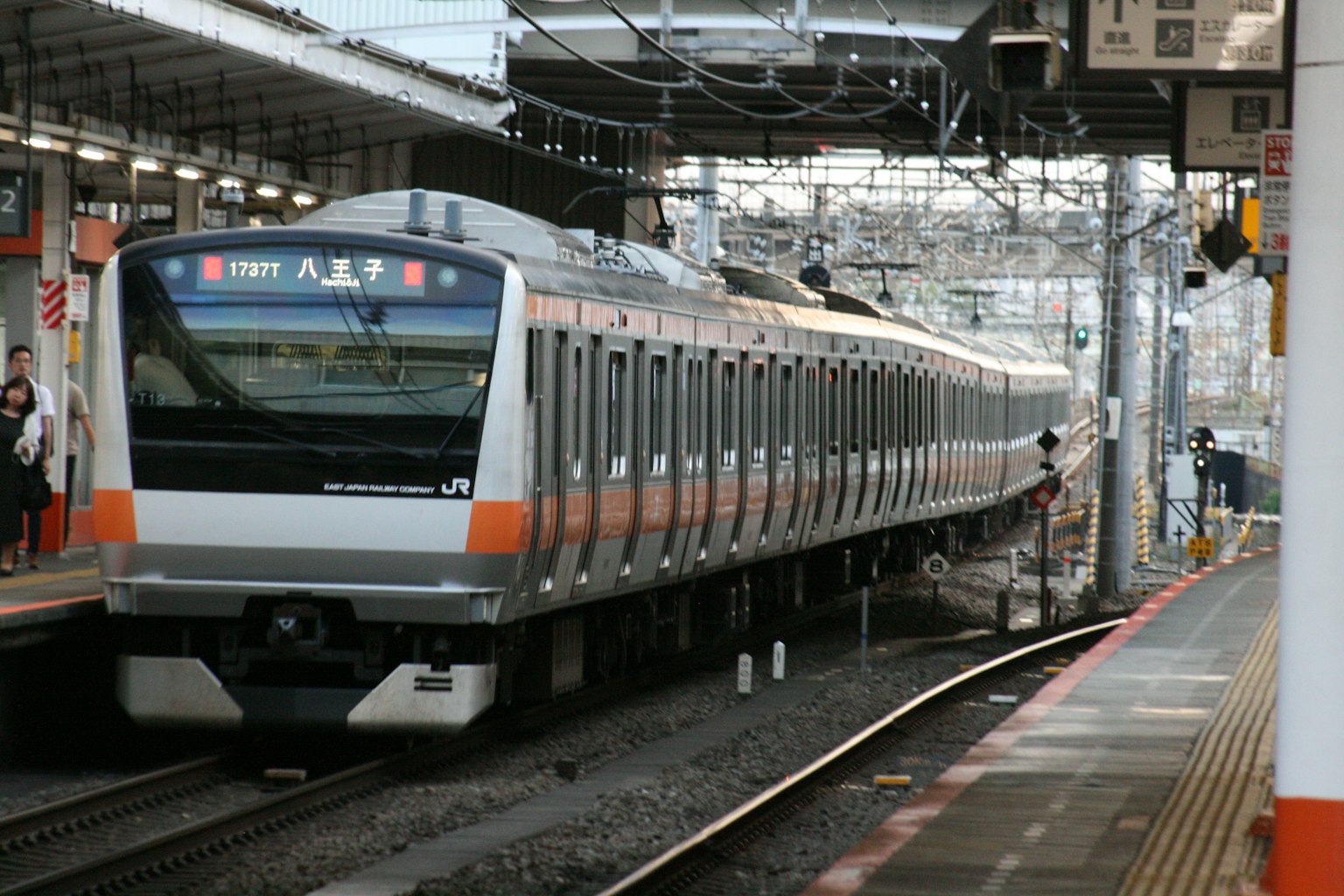 Kereta oranye dan abu-abu berhenti di stasiun Jepang
