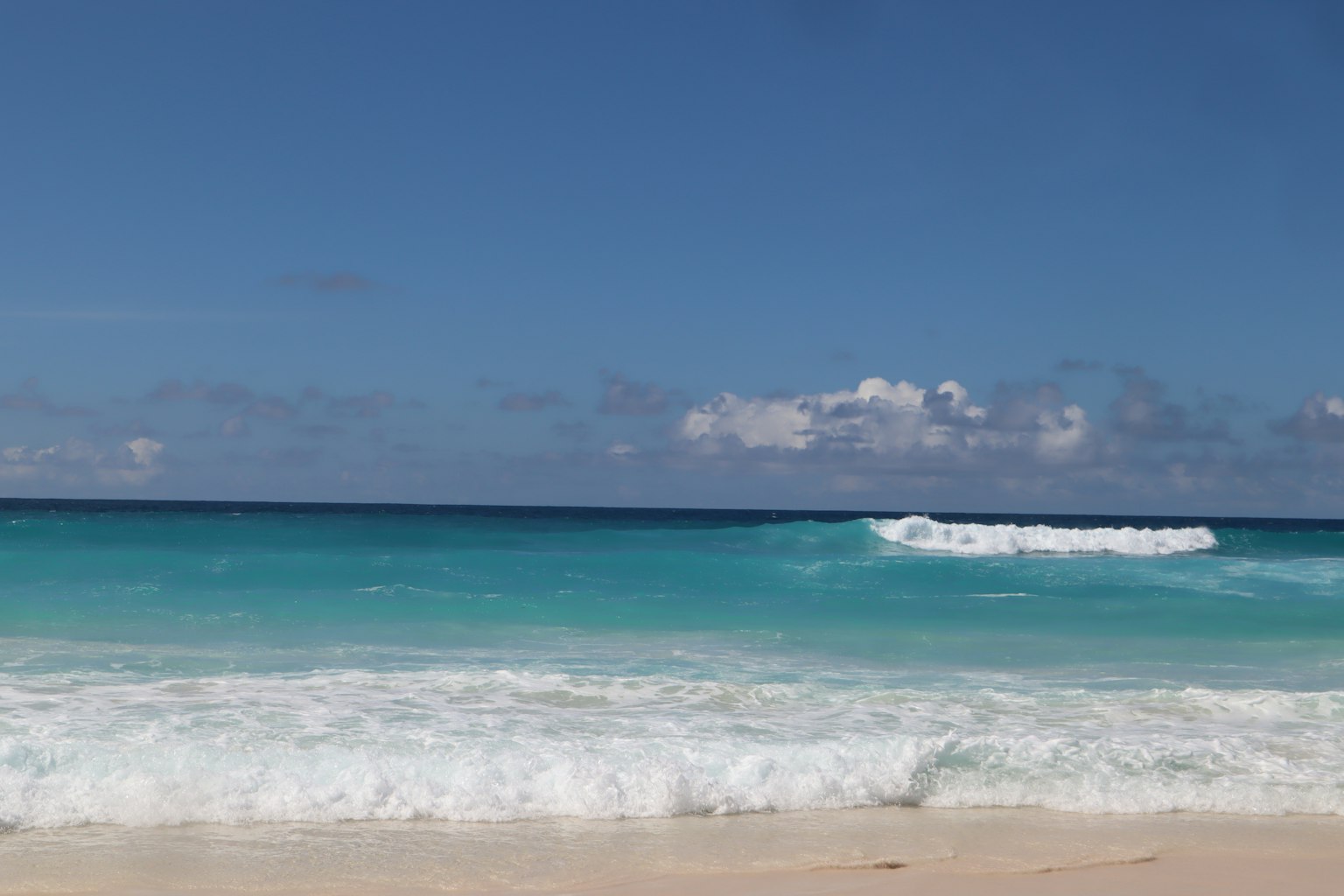 Vue pittoresque d'une plage avec de l'eau turquoise et des vagues blanches