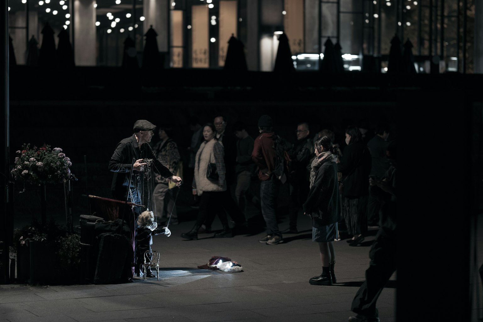 暗い街角でパフォーマンスをする男性と観客の群れ