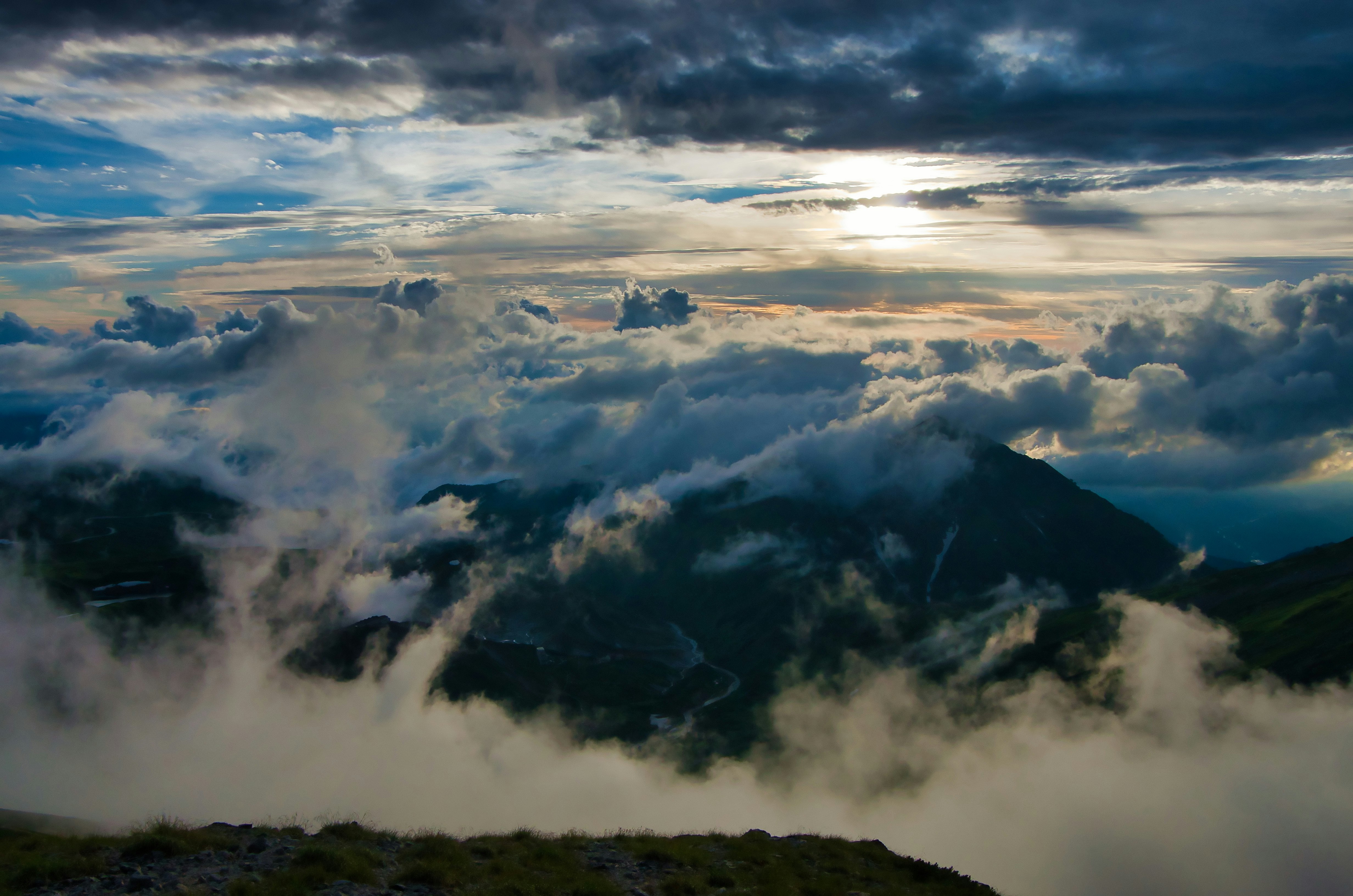 立山・真砂岳山頂を雲海と夕立が覆う夕暮れの空