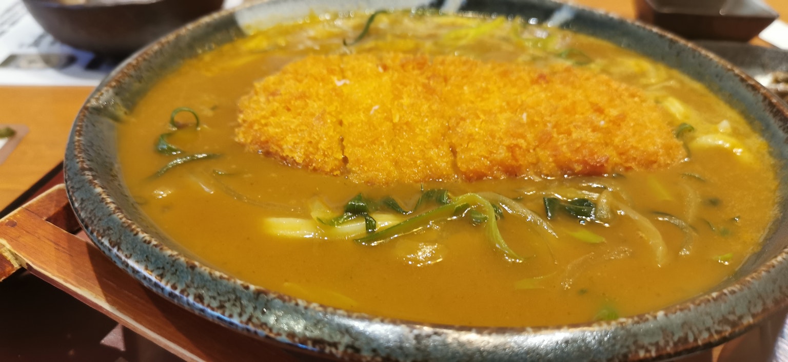 Un bol de udon au curry garni de tonkatsu croustillant