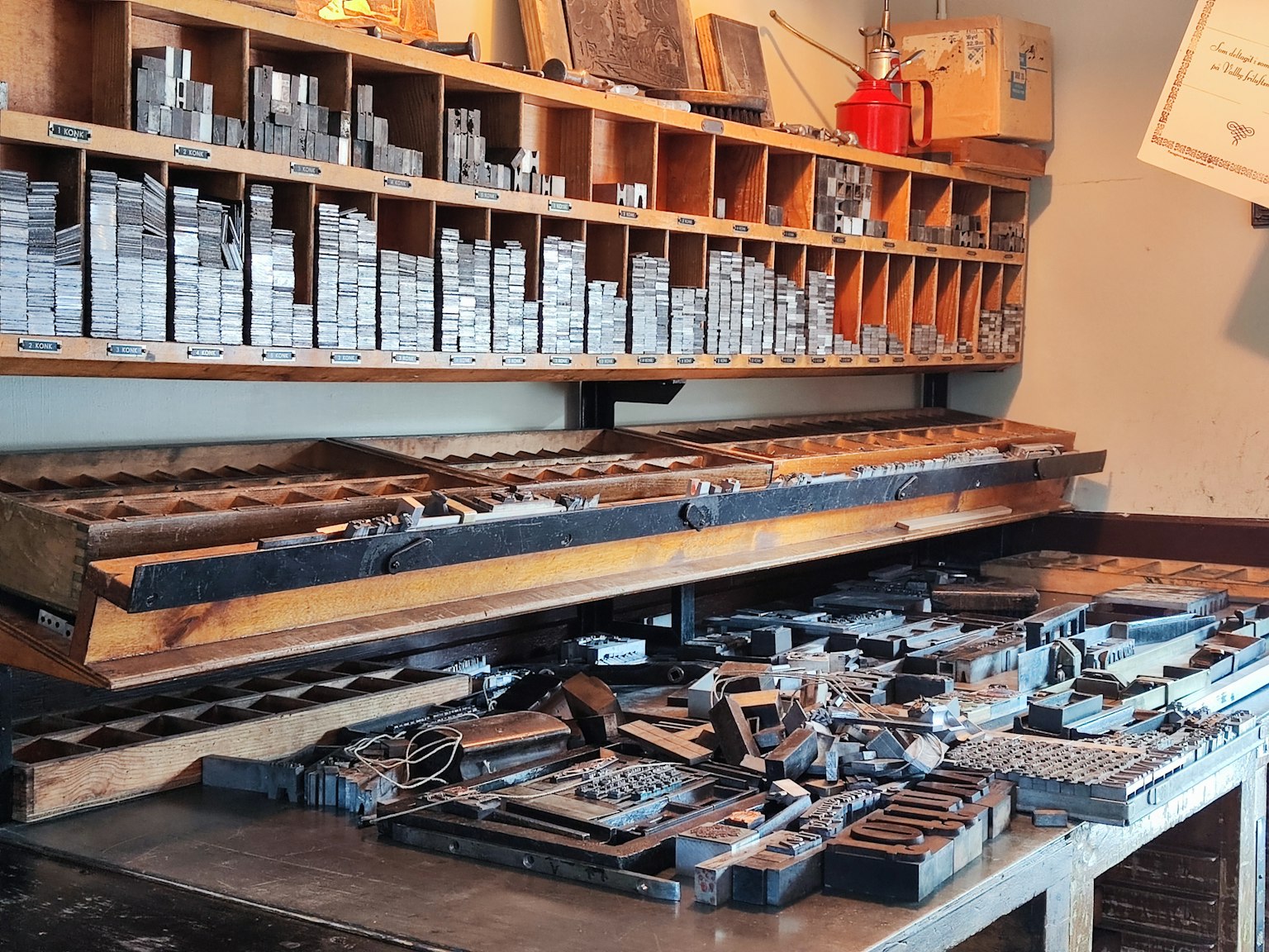 Un taller de impresión con tipos y herramientas esparcidos en la mesa de trabajo