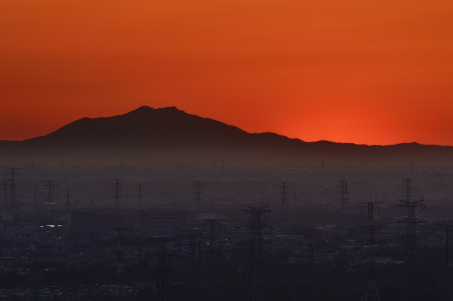 Un bellissimo tramonto arancione che illumina il profilo di una montagna