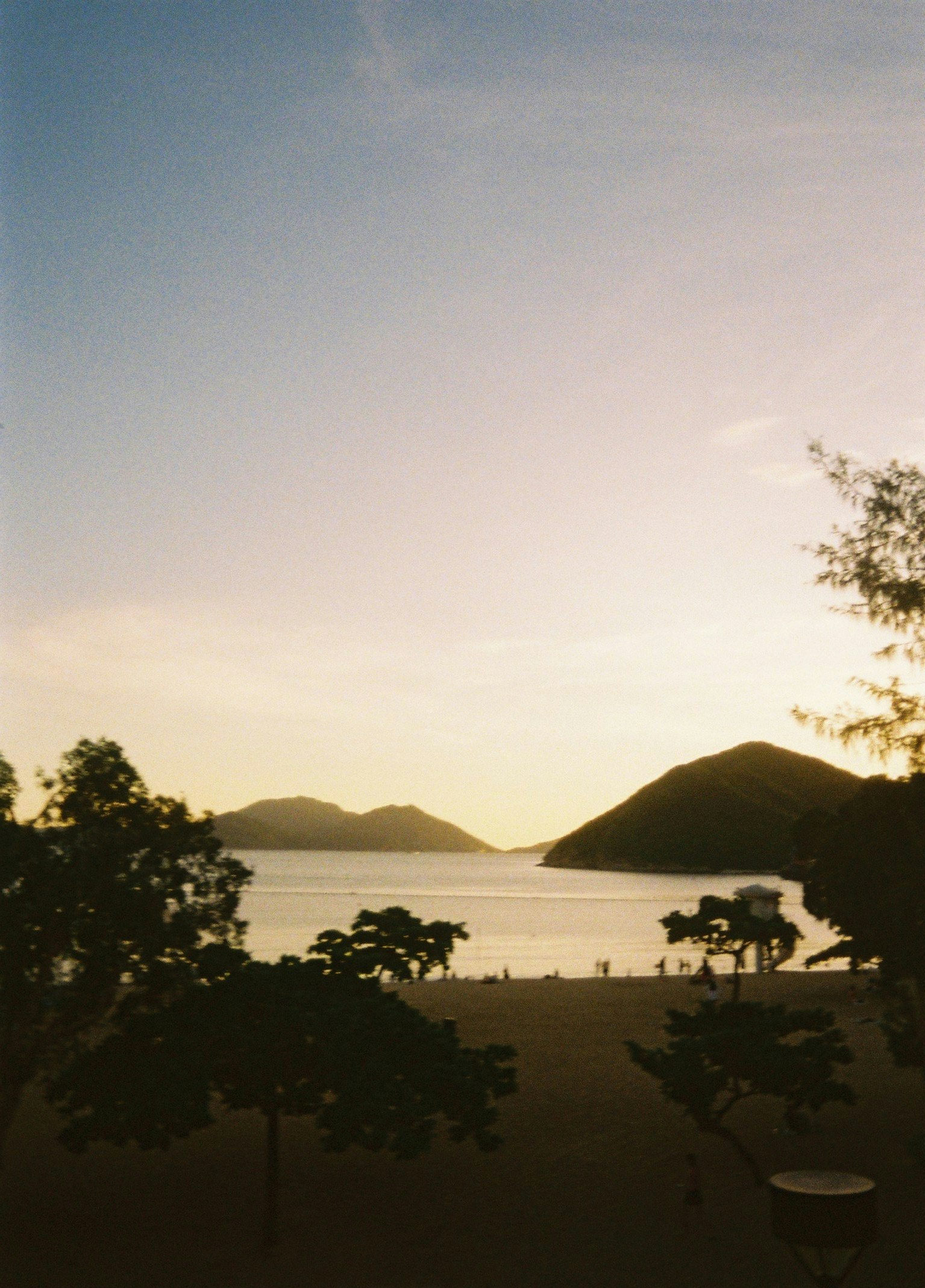 Blick auf den Strand bei Sonnenuntergang, ruhiges Meer und Hügel