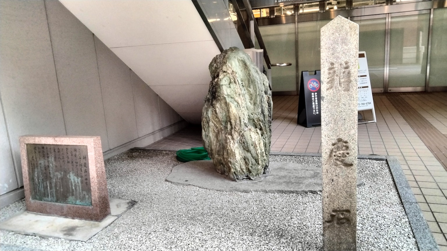 Ein öffentlicher Raum mit einem Steindenkmal und einer Steinskulptur