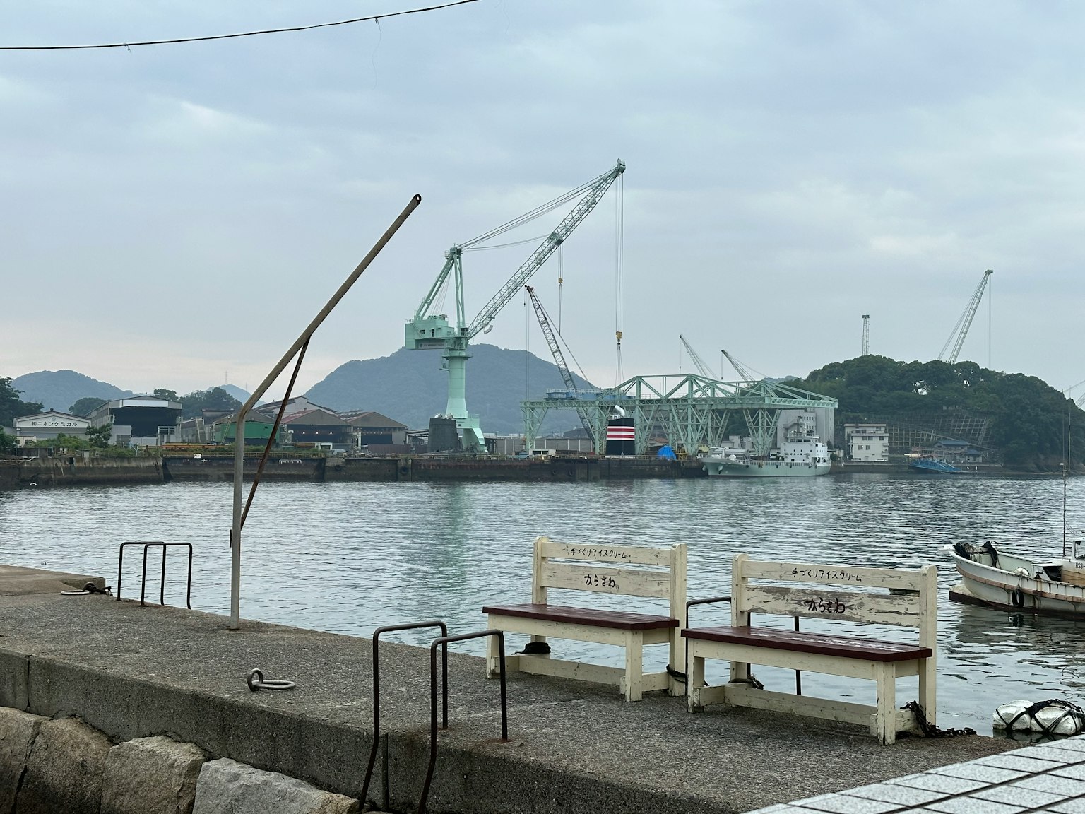 ทิวทัศน์ท่าเรือที่มีเครนและภูเขา