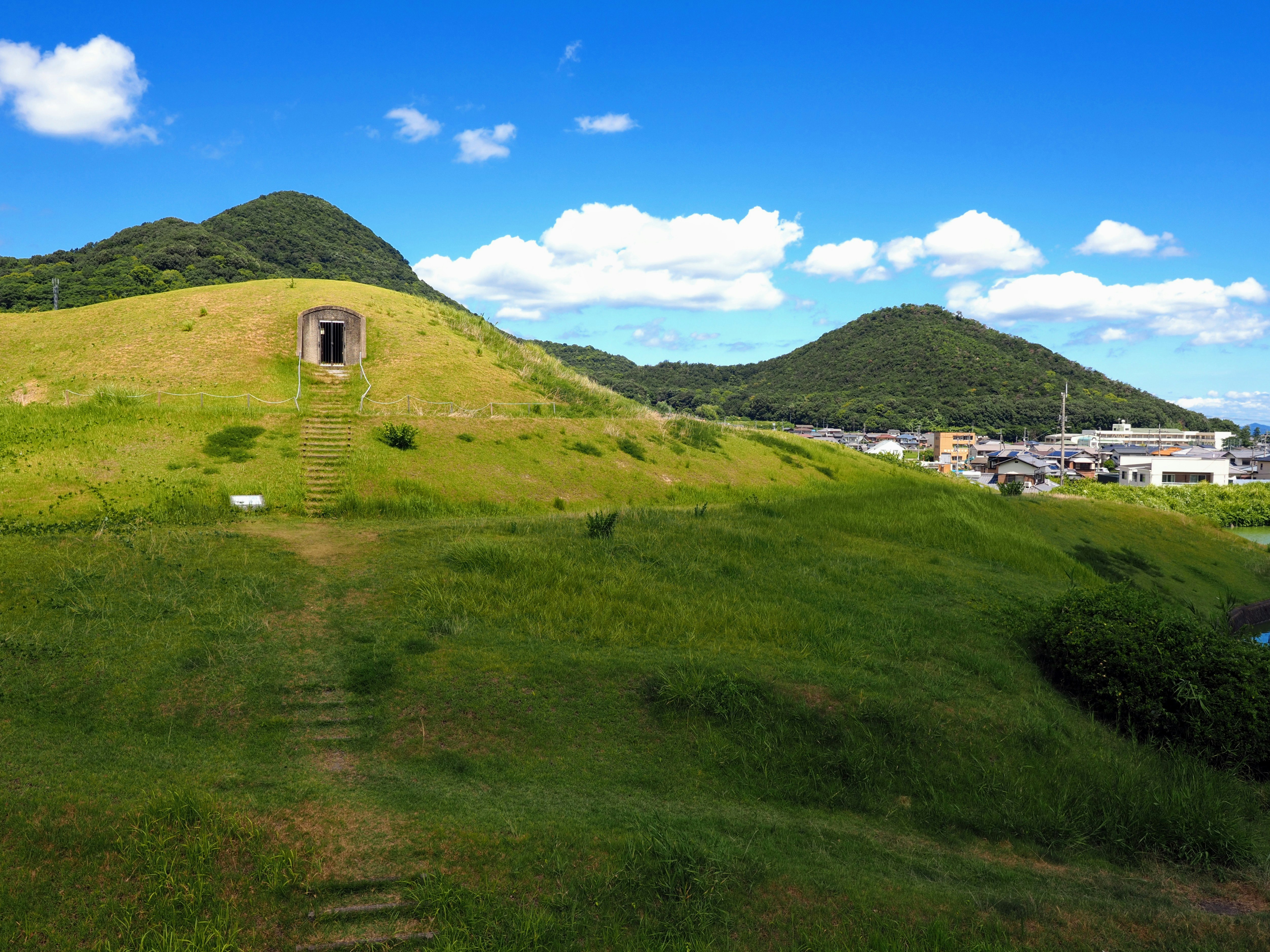 草坡山丘與小型石質教堂及山脈風景