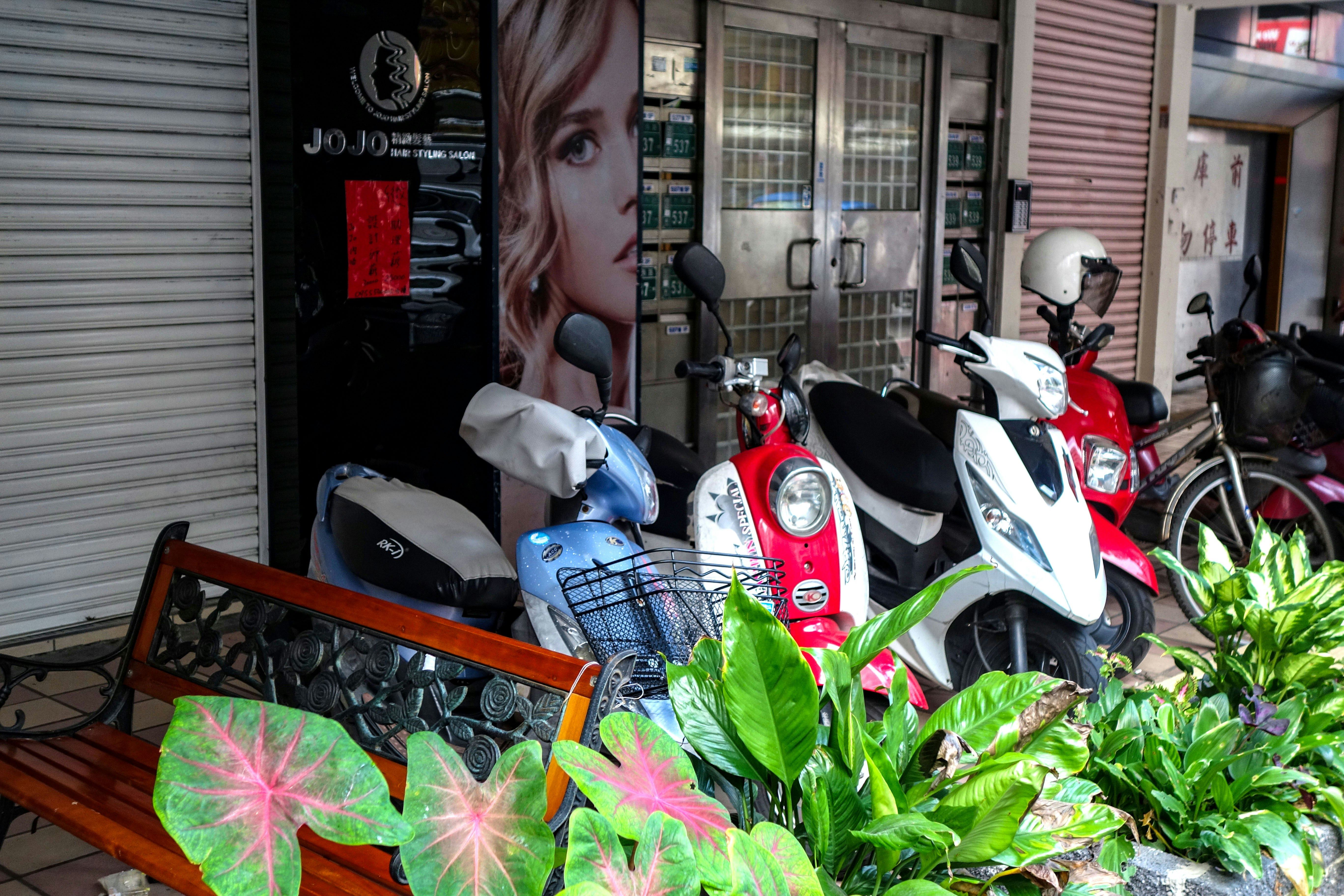 台湾の路地に並ぶスクーターと花のある店先