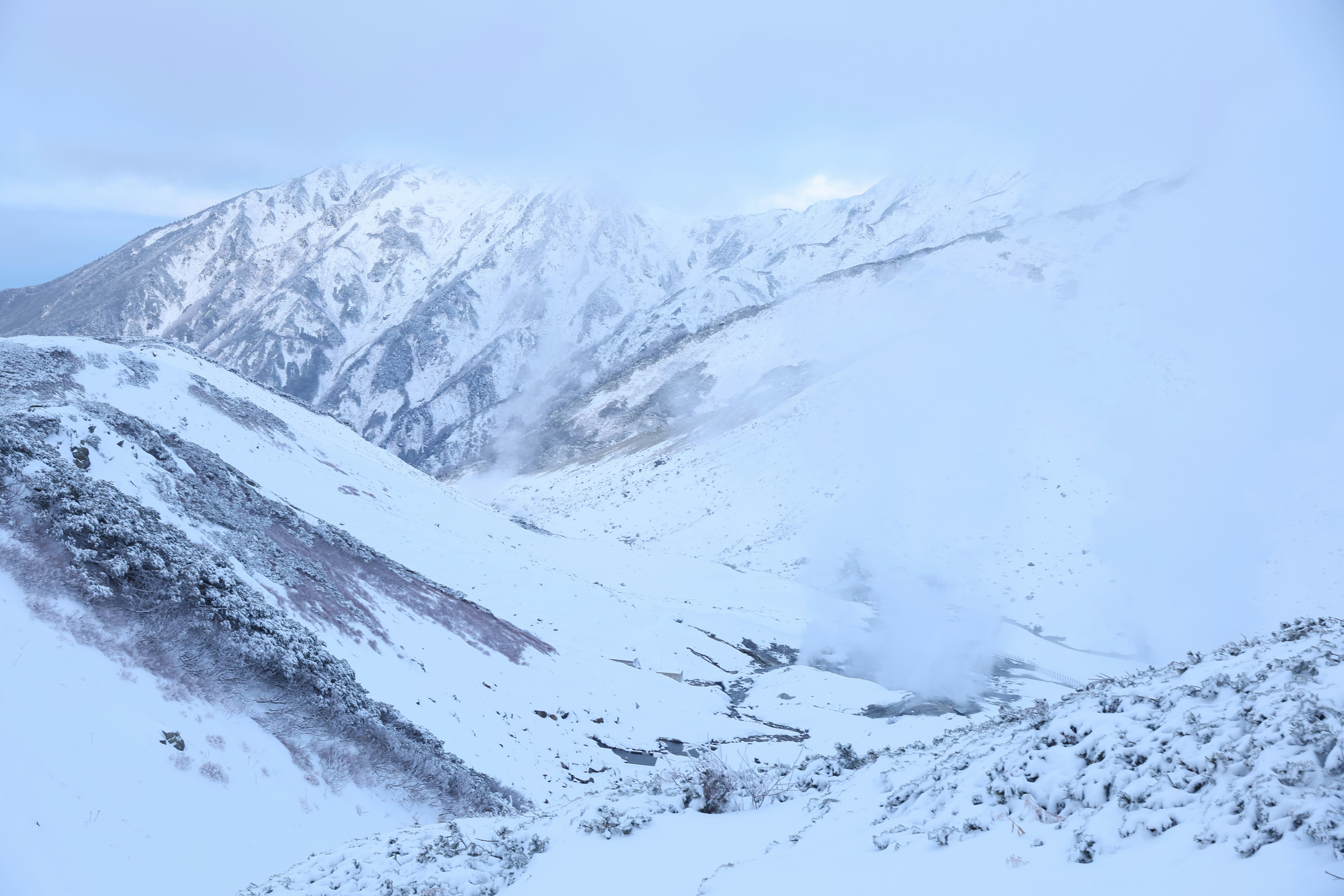 雪に覆われた山並みと谷の風景