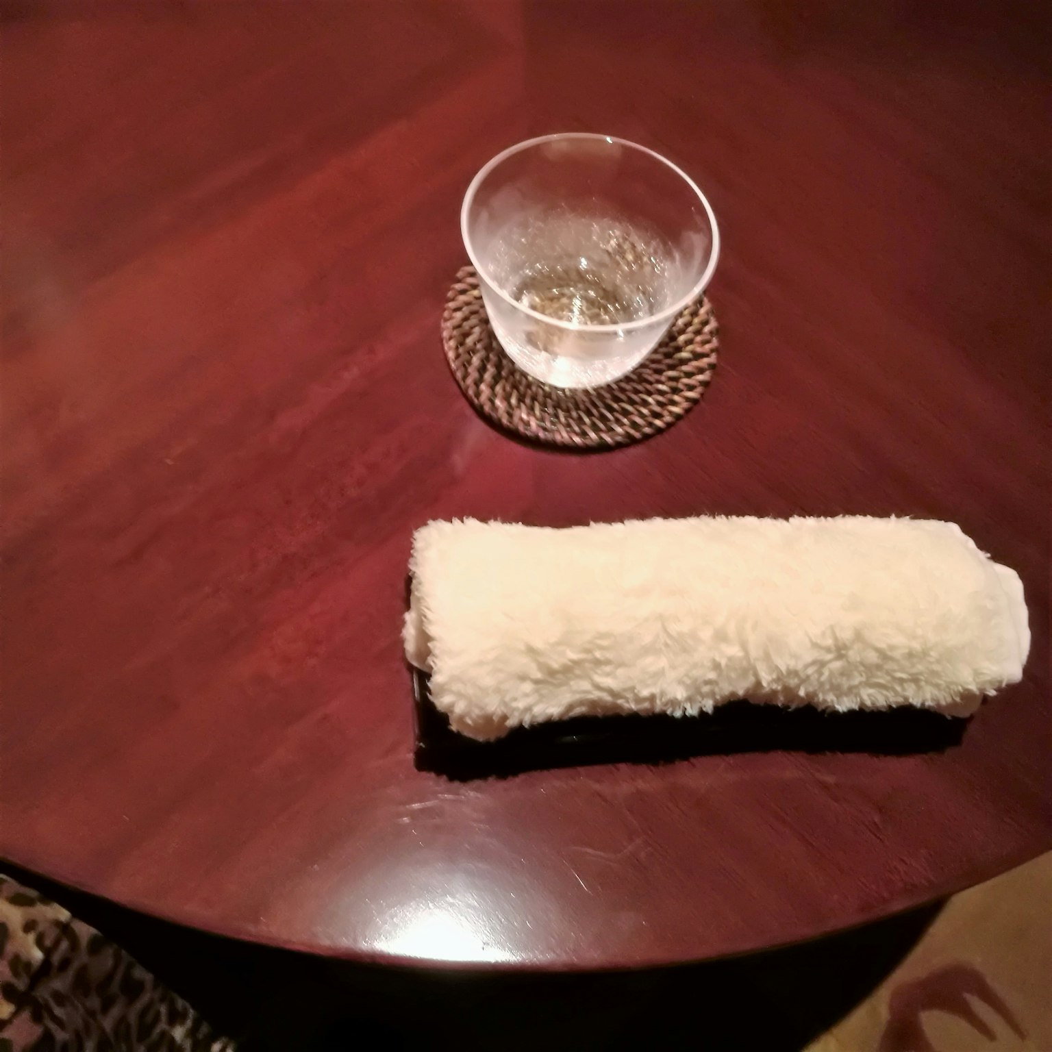 木桌上的白色毛巾和透明杯子