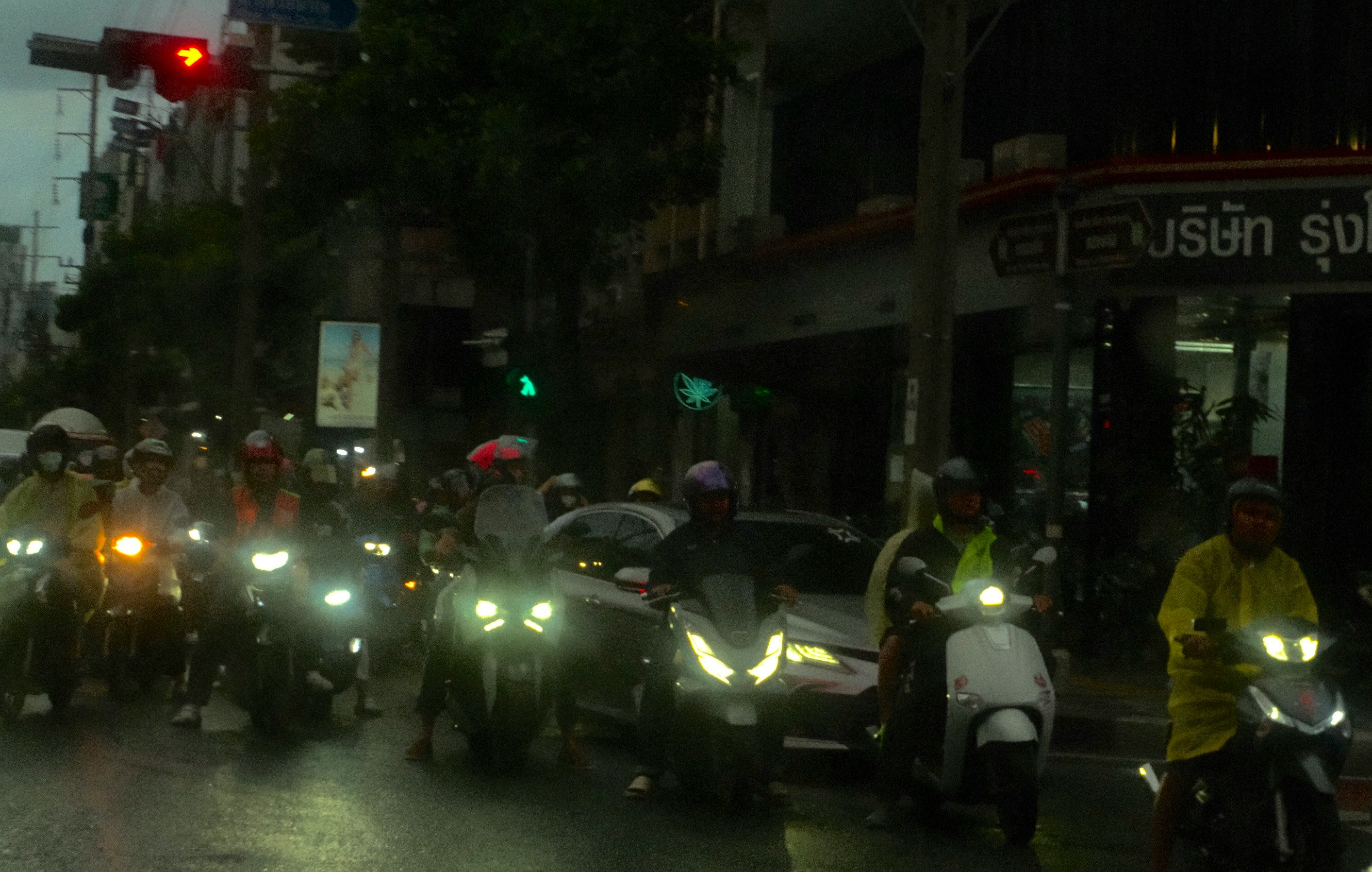夜の街でヘッドライトを点けたバイクが並ぶ交差点