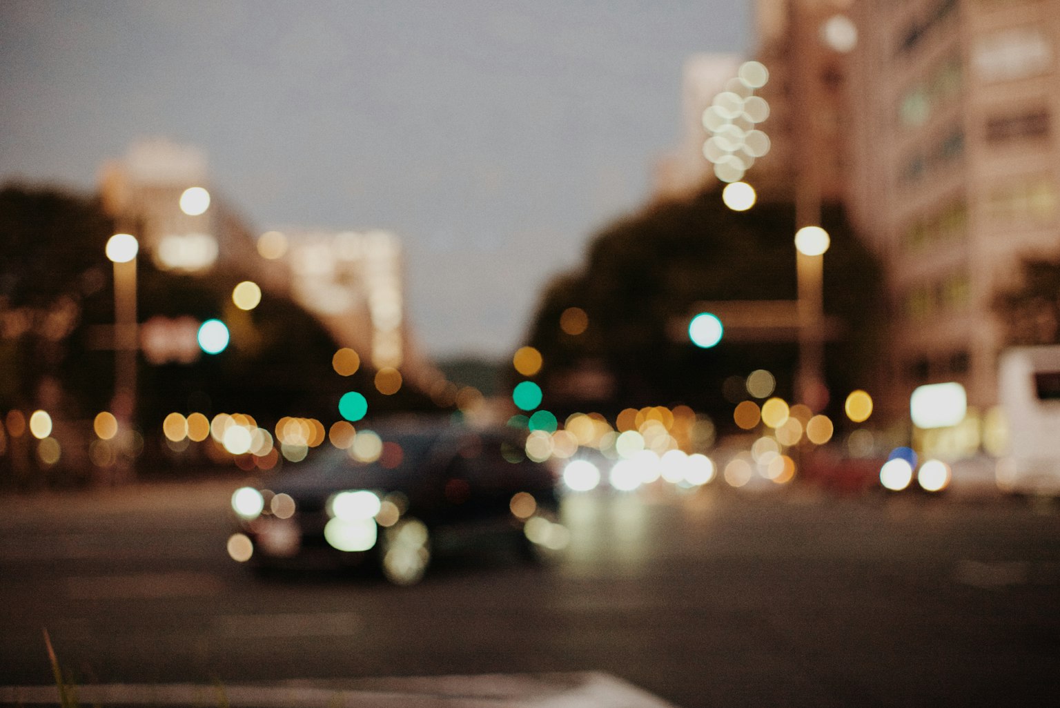 模糊的夜晚城市交叉口,有一辆黑色汽车和许多灯光