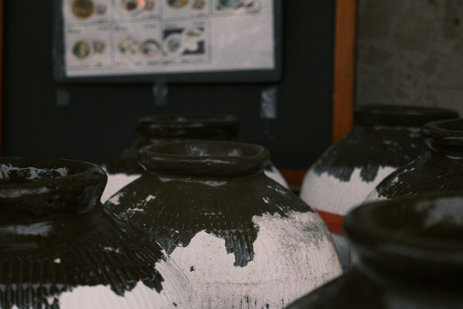 Une collection de pots en céramique avec un glaçage noir et blanc