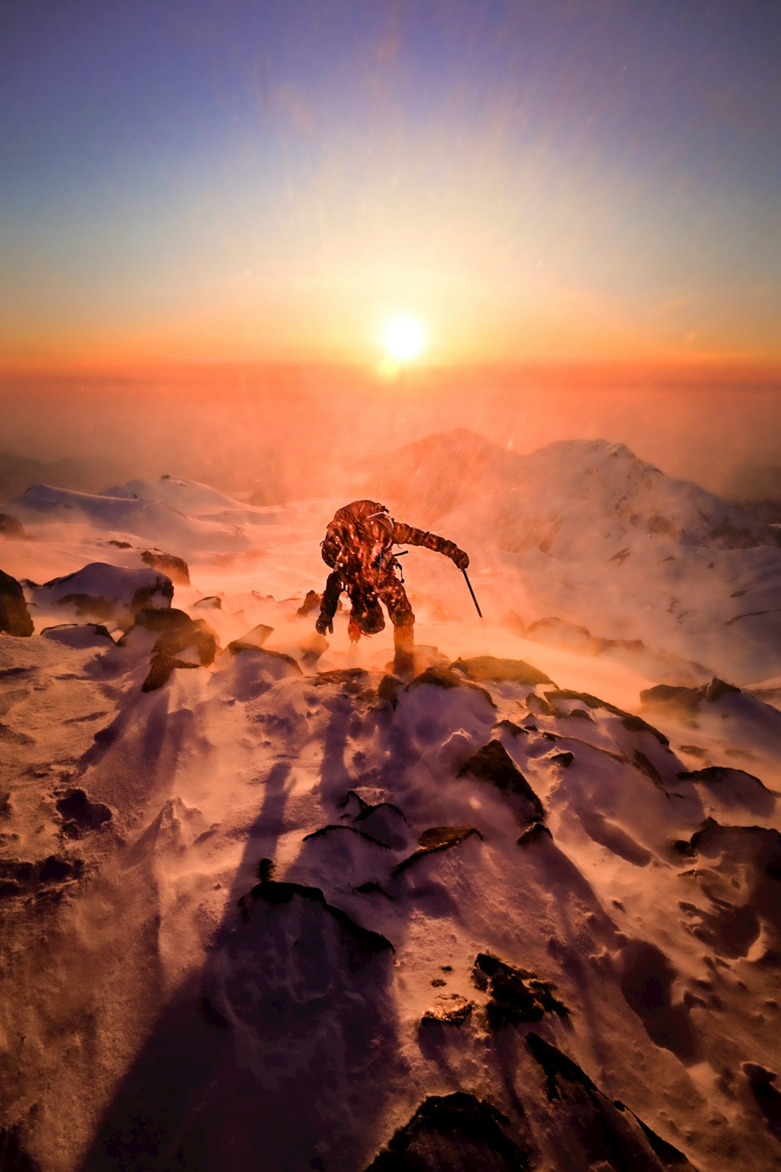 登山者站在雪山頂上，背景是日落