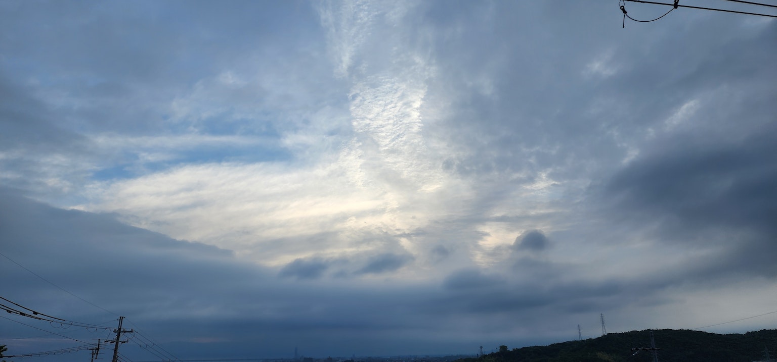 Ein Wolkenmuster gegen einen blauen Himmel mit kontrastierendem Licht