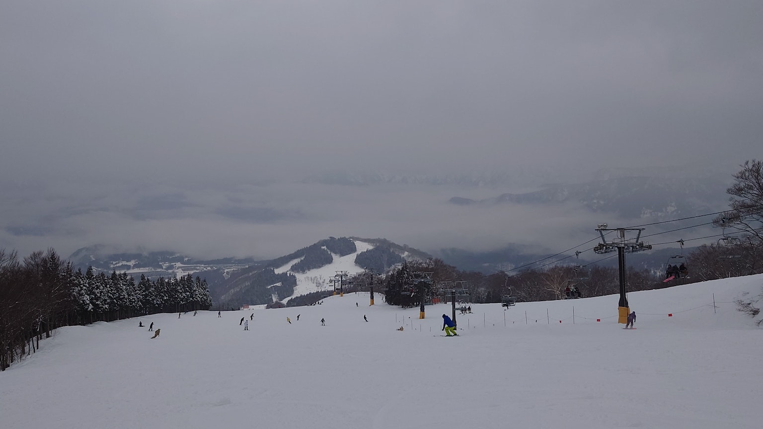 Schneebedeckte Berge mit einem Skilift unter einem bewölkten Himmel